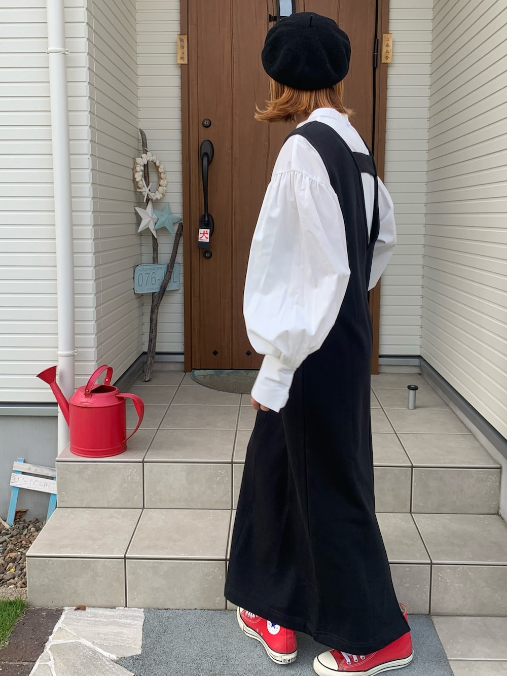 ブラック系のジャンパースカート、ホワイト系のシャツ/ブラウスを着用したレディースの秋コーディネートの3枚目の写真