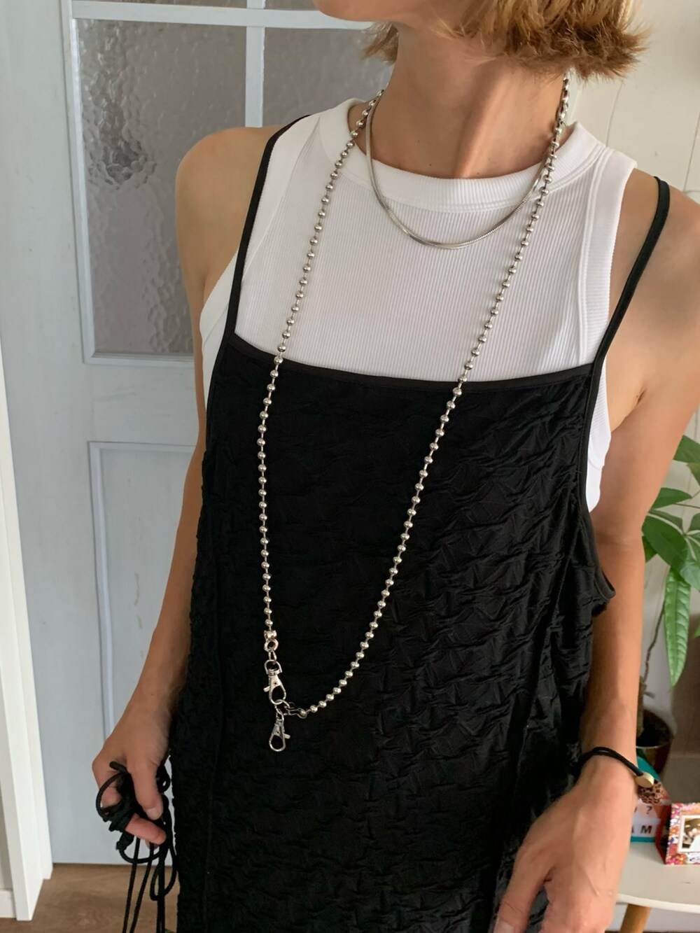 ホワイト系のタンクトップ、ブラック系のワンピースを着用したレディースの夏コーディネートの3枚目の写真