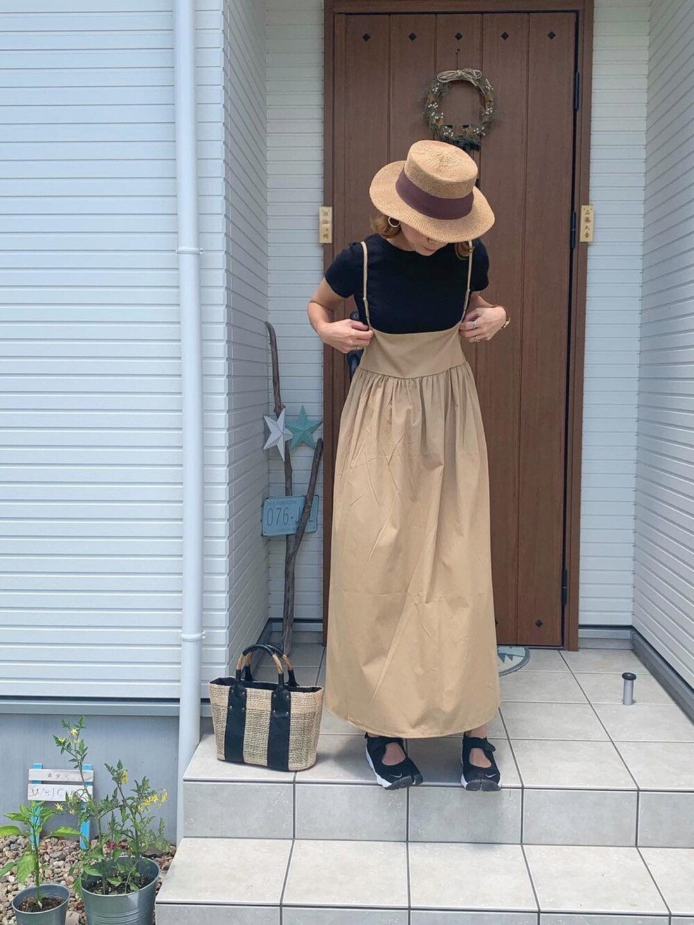 ベージュ系のスカート、ブラック系のスニーカーを着用したレディースの春コーディネートの2枚目の写真