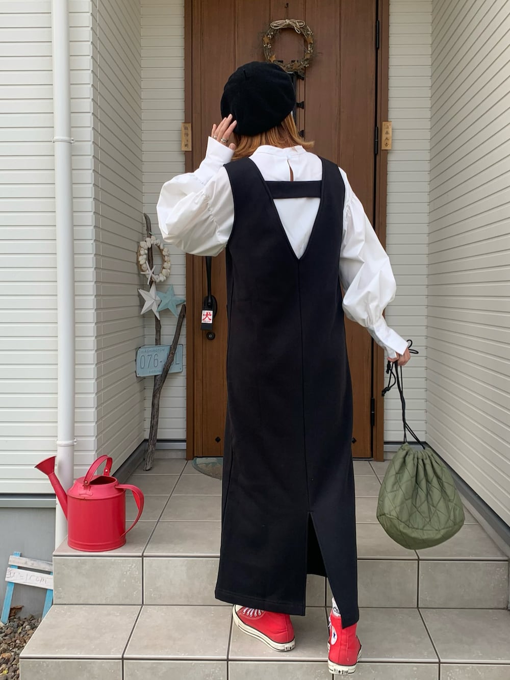 ブラック系のジャンパースカート、ホワイト系のシャツ/ブラウスを着用したレディースの秋コーディネートの2枚目の写真