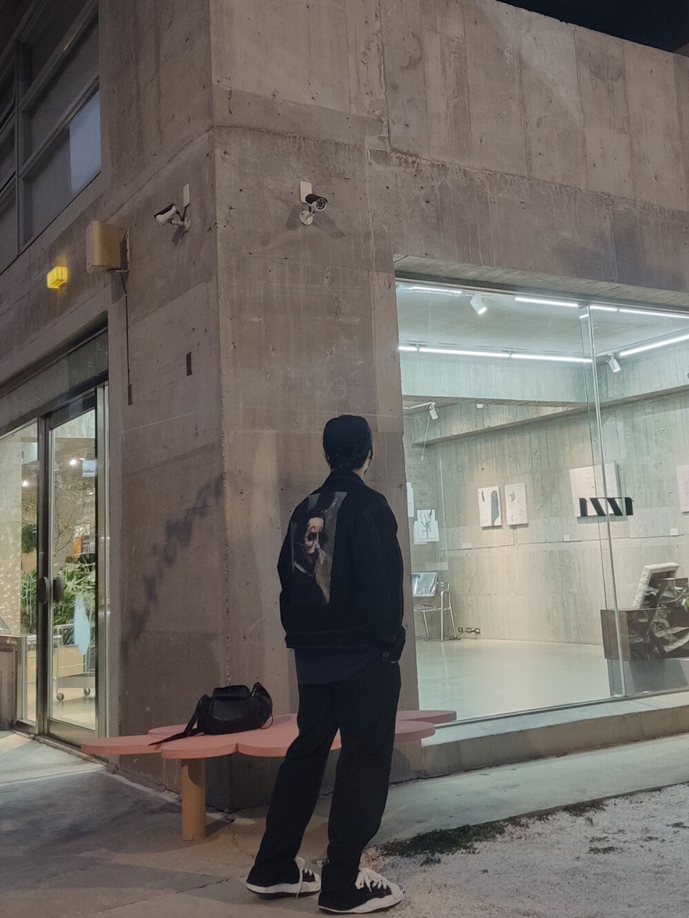 ブラック系のチノパンツ、ブラック系のデニムジャケット、ブラック系のスニーカーを着用したメンズの秋コーディネートの2枚目の写真