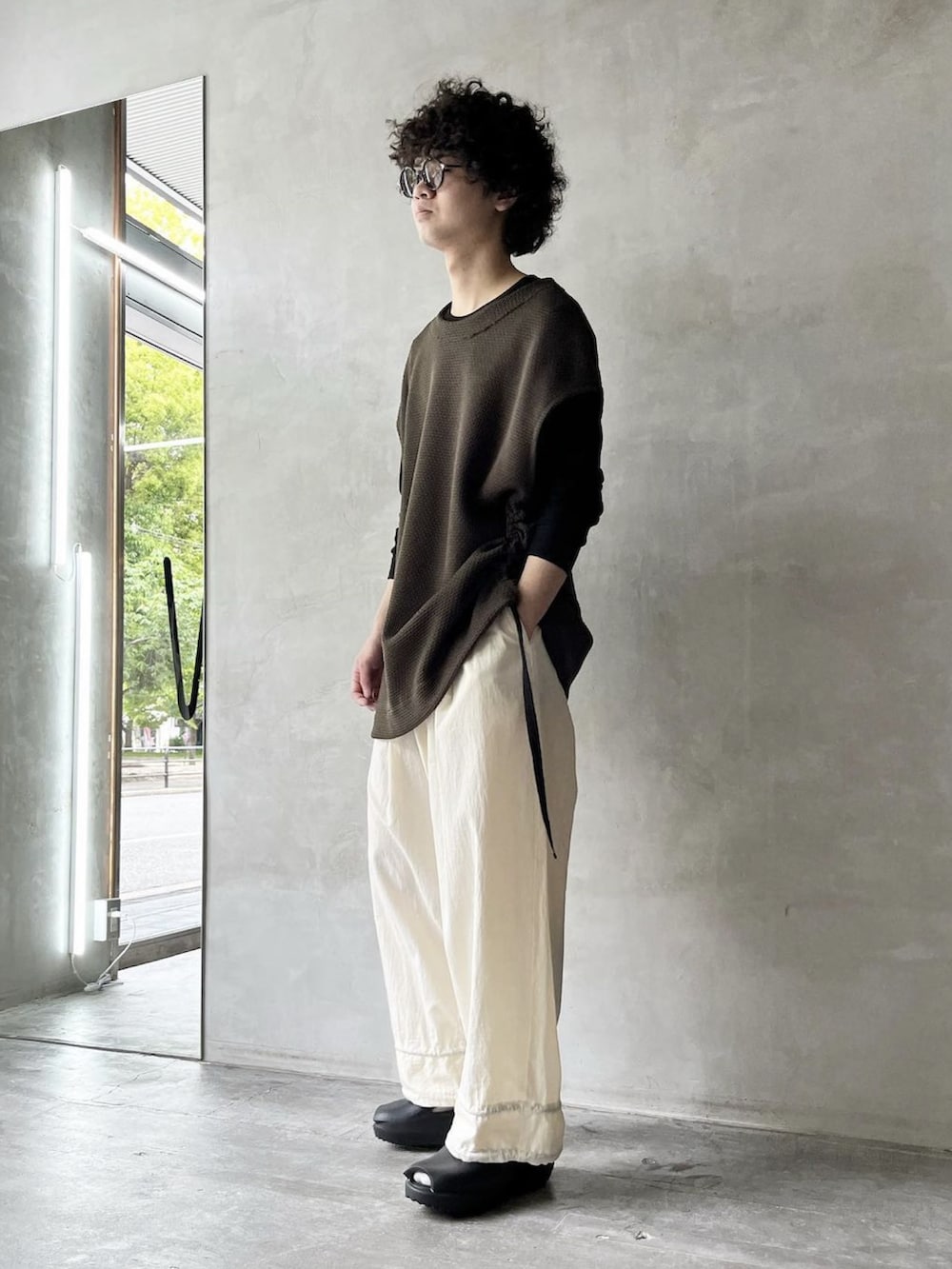 ホワイト系のその他パンツ、グリーン系のベスト、ブラック系のその他アウターを着用したメンズの春コーディネートの3枚目の写真