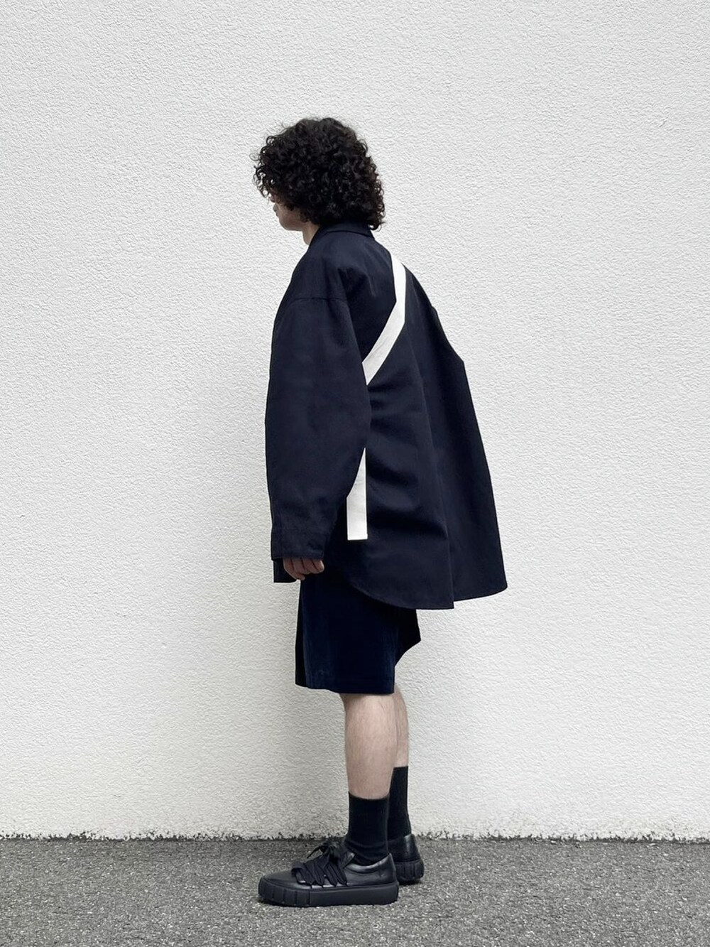 ブラック系のスニーカー、ブルー系のその他パンツ、ブルー系のシャツ/ブラウスを着用したメンズの秋コーディネートの3枚目の写真