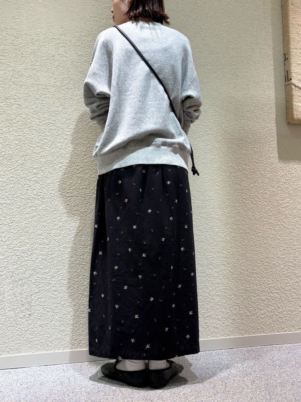 ブラック系のスカート、ブラック系のショルダーバッグ、シルバー系のネックレスを着用したレディースの冬コーディネートの7枚目の写真