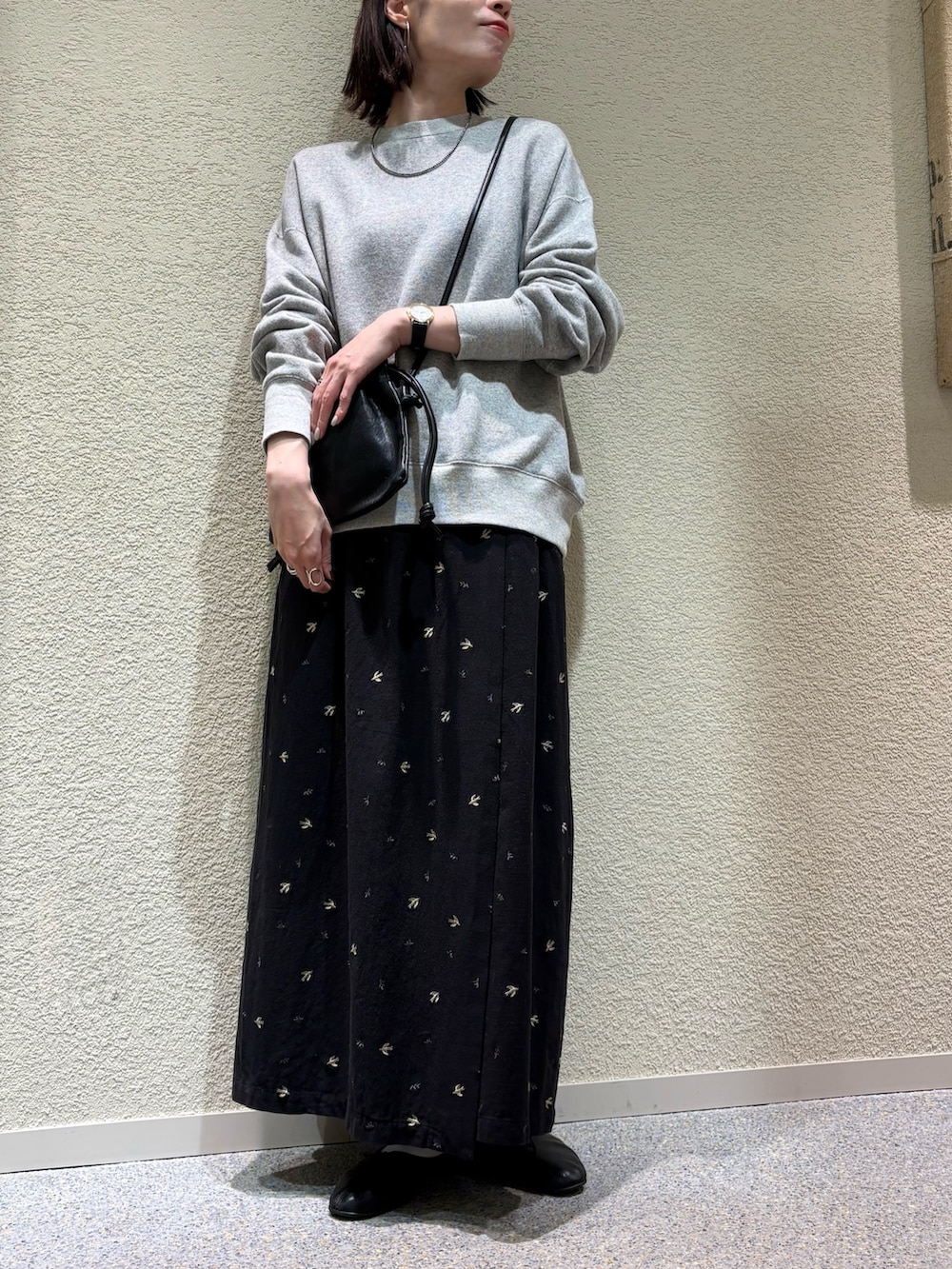 ブラック系のスカート、ブラック系のショルダーバッグ、シルバー系のネックレスを着用したレディースの冬コーディネートの5枚目の写真