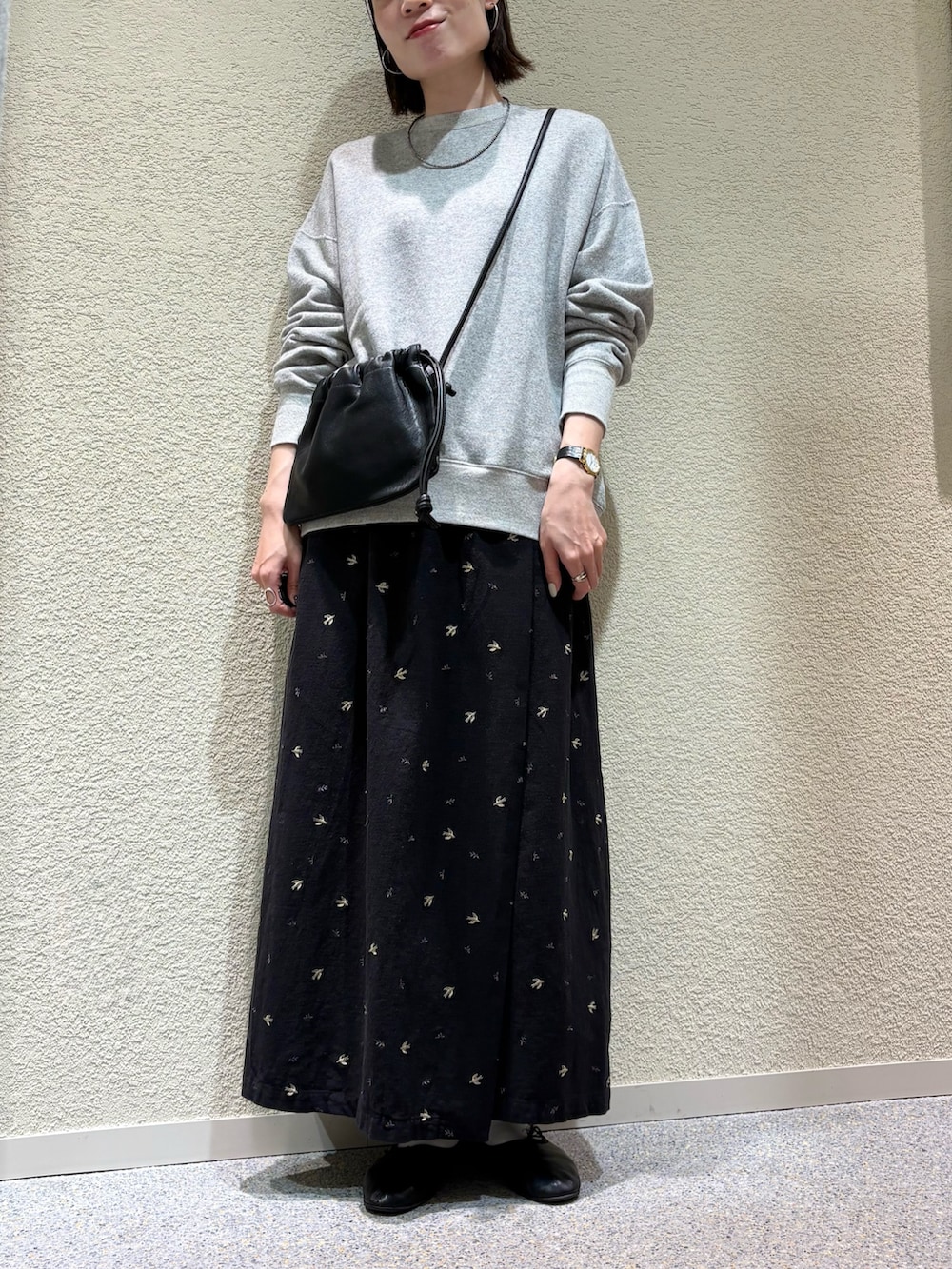 ブラック系のスカート、ブラック系のショルダーバッグ、シルバー系のネックレスを着用したレディースの冬コーディネートの3枚目の写真