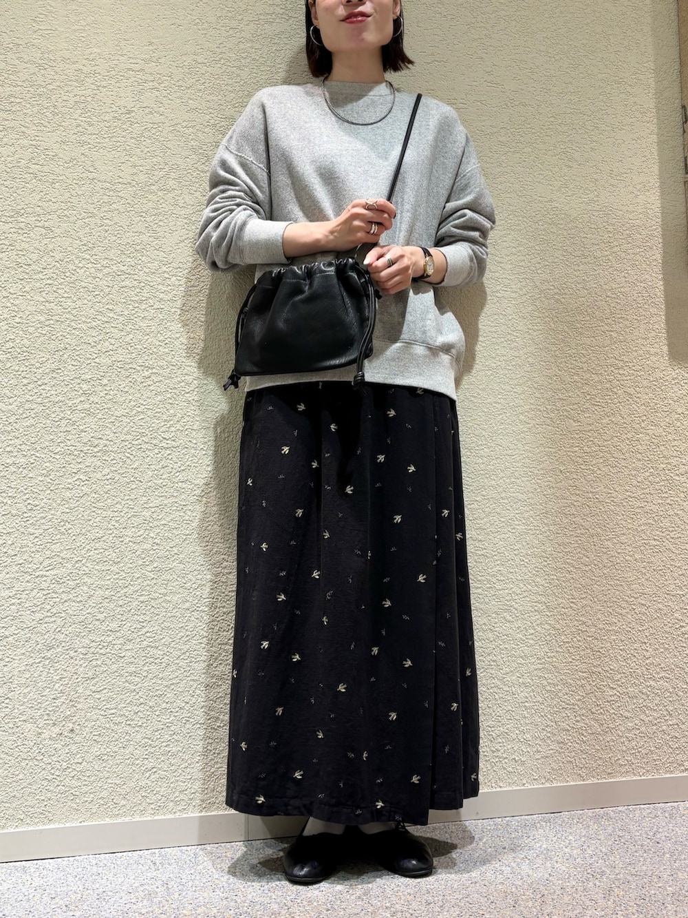 ブラック系のスカート、ブラック系のショルダーバッグ、シルバー系のネックレスを着用したレディースの冬コーディネートの2枚目の写真