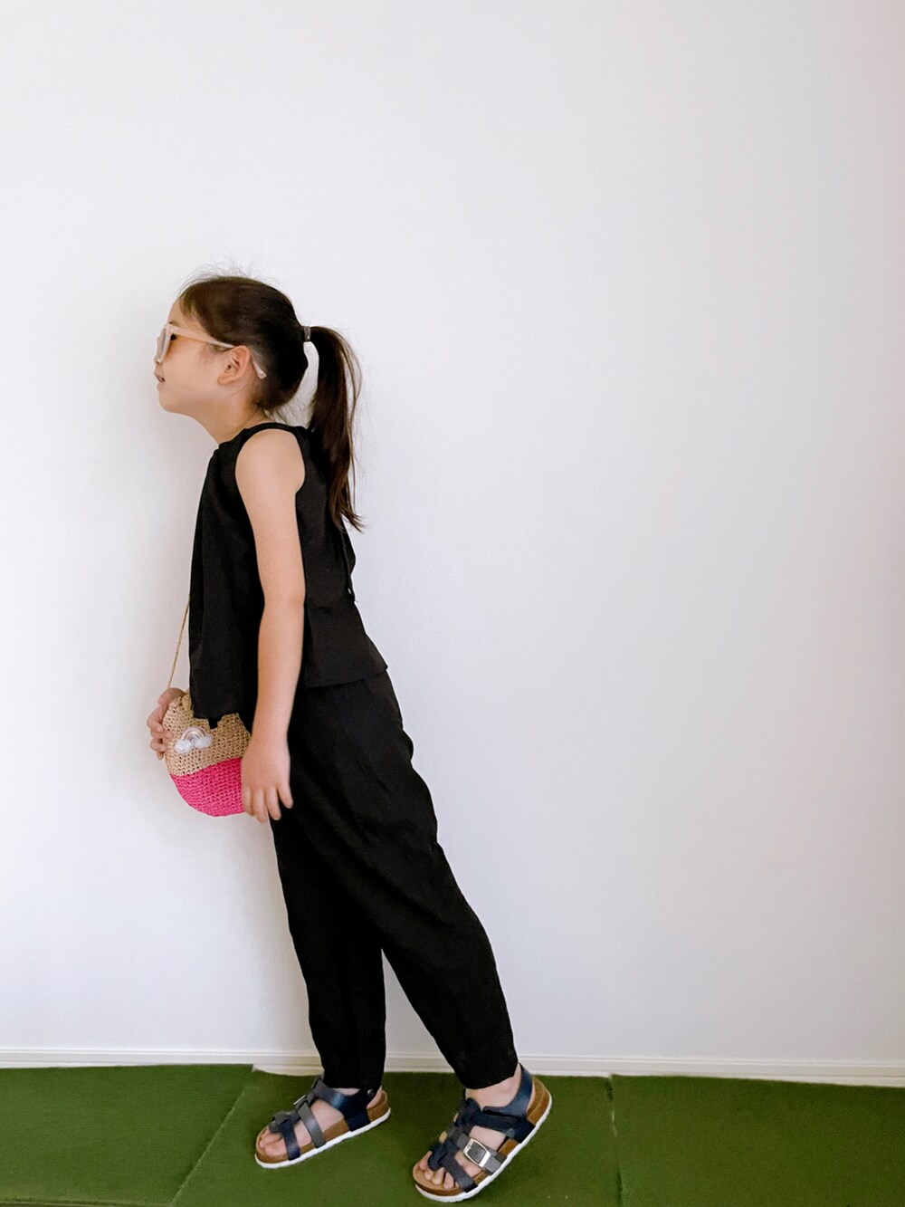 ブラック系のキャミソール、ブラック系のその他パンツ、ピンク系のかごバッグを着用したキッズの夏コーディネートの2枚目の写真