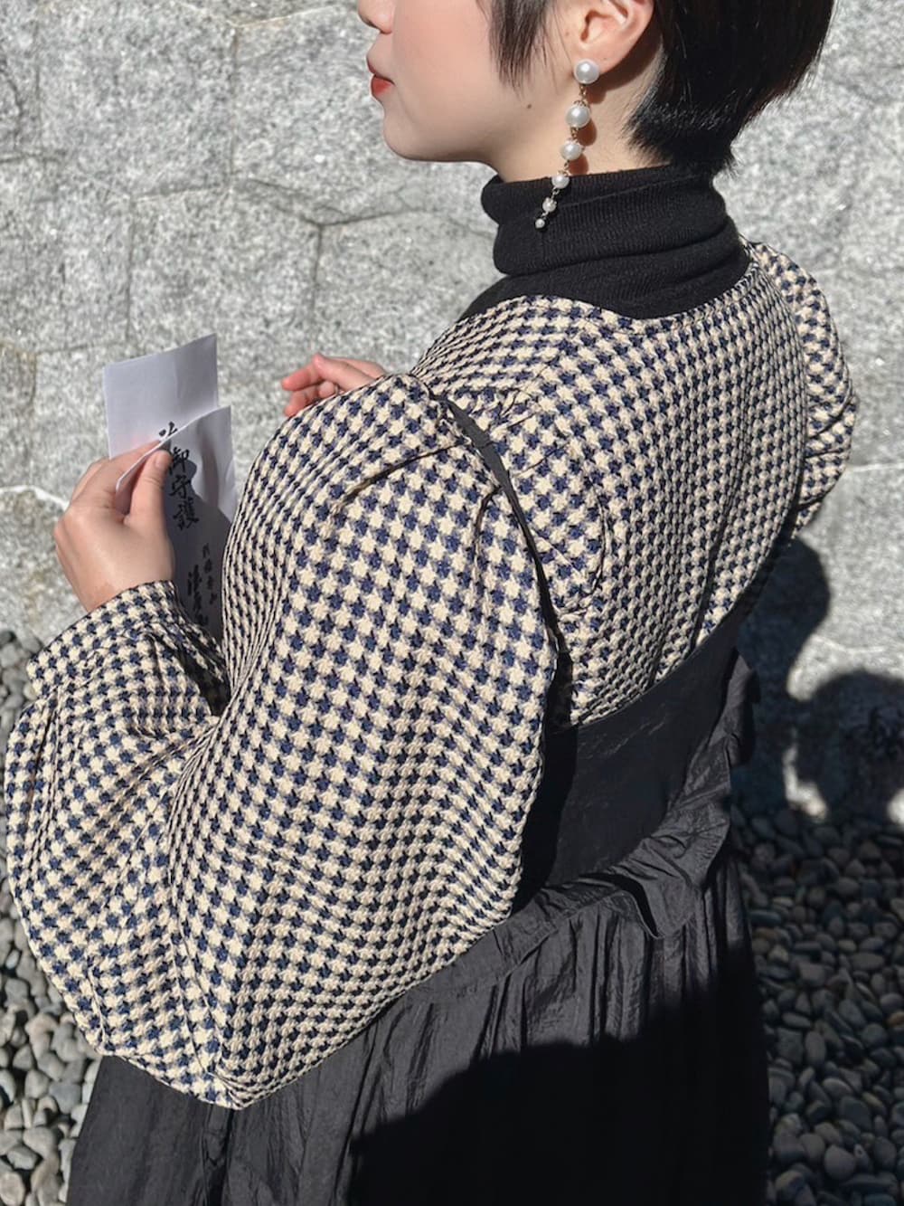 ブラック系のワンピースを着用したレディースの冬コーディネートの2枚目の写真