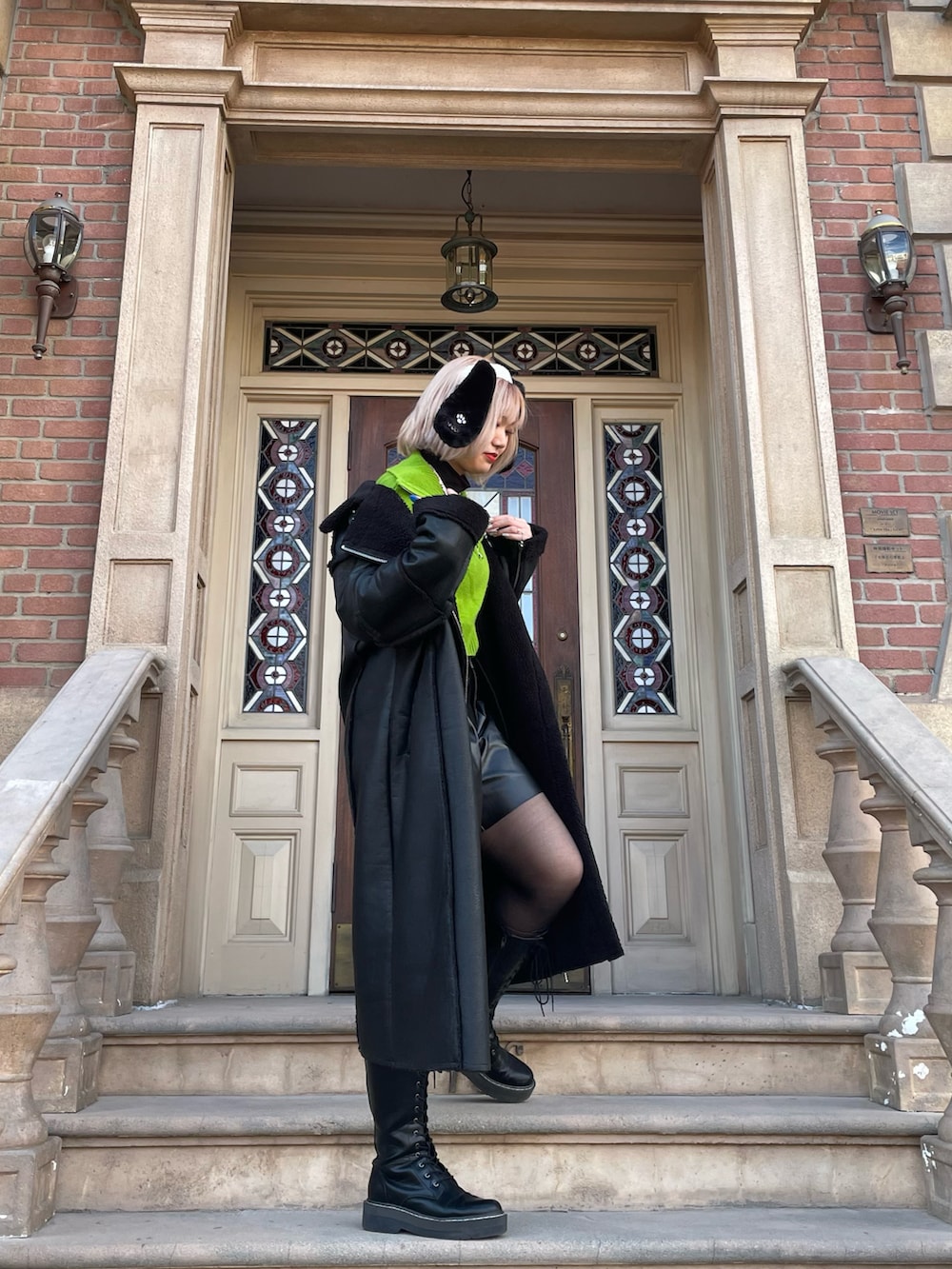 グリーン系のニット/セーター、ブラック系のショルダーバッグ、ホワイト系のボストンバッグを着用したレディースの冬コーディネートの3枚目の写真