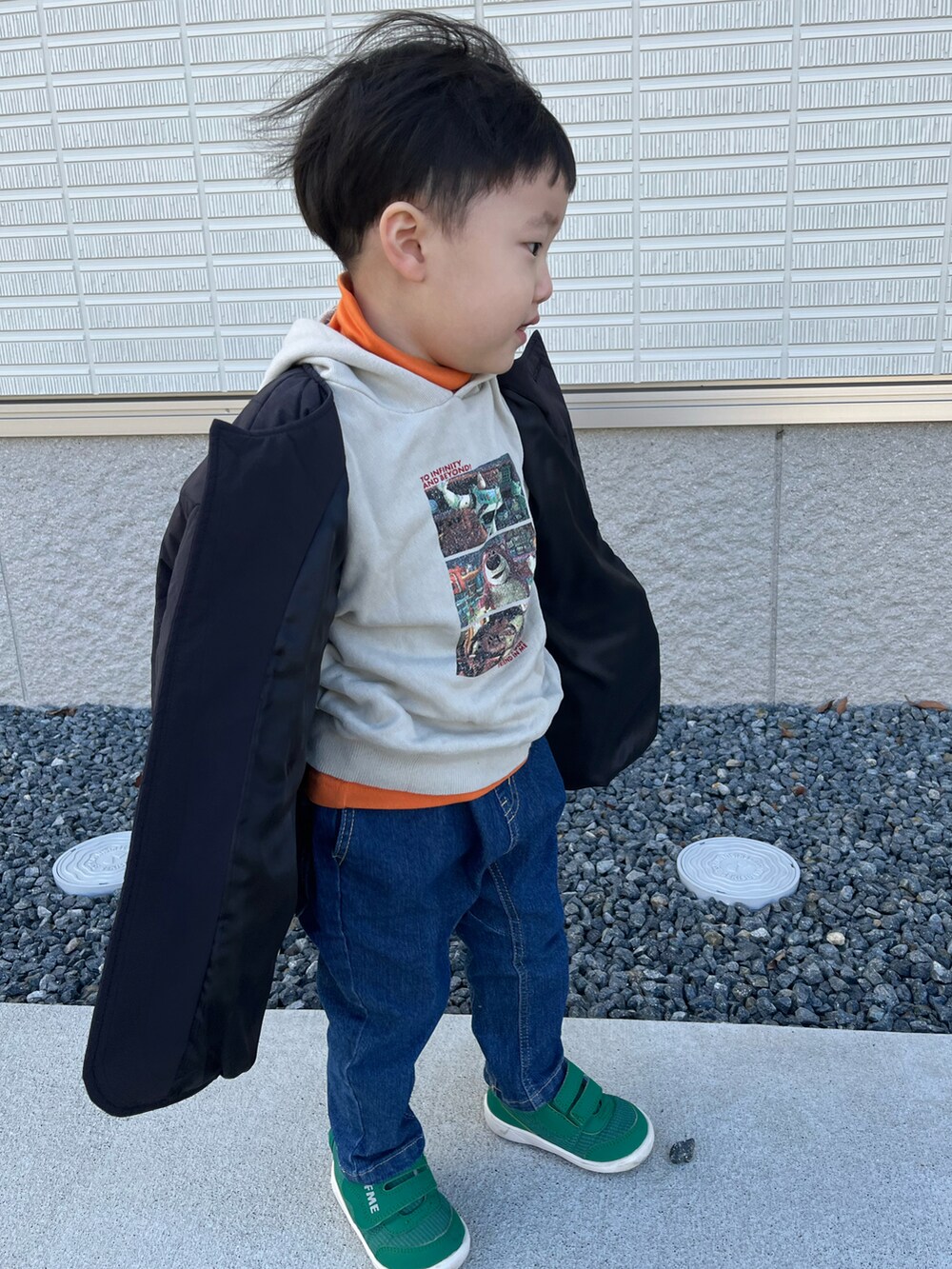 ブラック系のブルゾン、オレンジ系のTシャツ/カットソー、ベージュ系のパーカーを着用したキッズの冬コーディネートの2枚目の写真