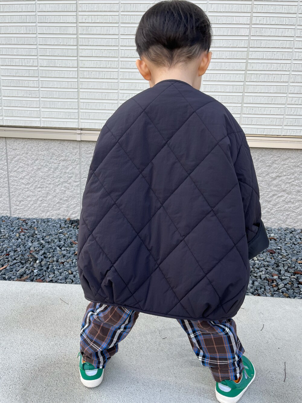 ブラック系のブルゾン、グリーン系のTシャツ/カットソー、ブラウン系のパンツを着用したキッズの秋コーディネートの2枚目の写真