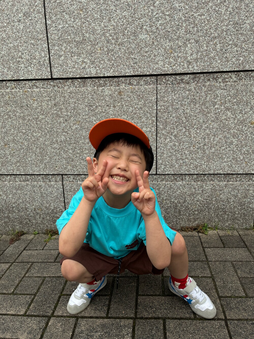 ブルー系のTシャツ/カットソー、ブラウン系のその他パンツ、オレンジ系のキャップを着用したキッズの春コーディネートの3枚目の写真