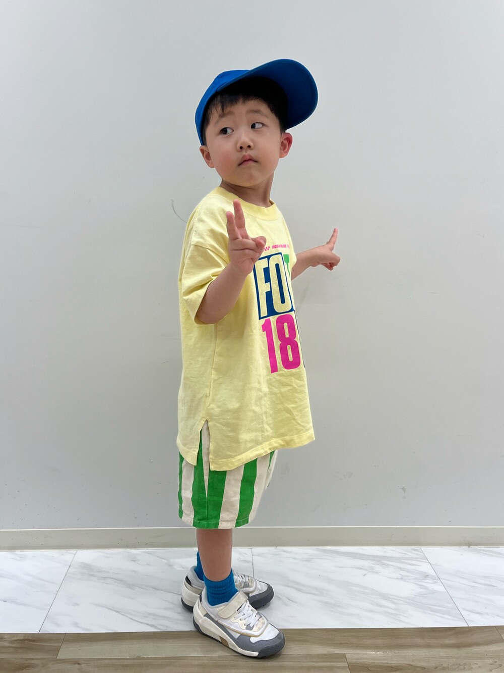 イエロー系のTシャツ/カットソー、グリーン系のその他パンツ、ブルー系のキャップを着用したキッズの春コーディネートの2枚目の写真