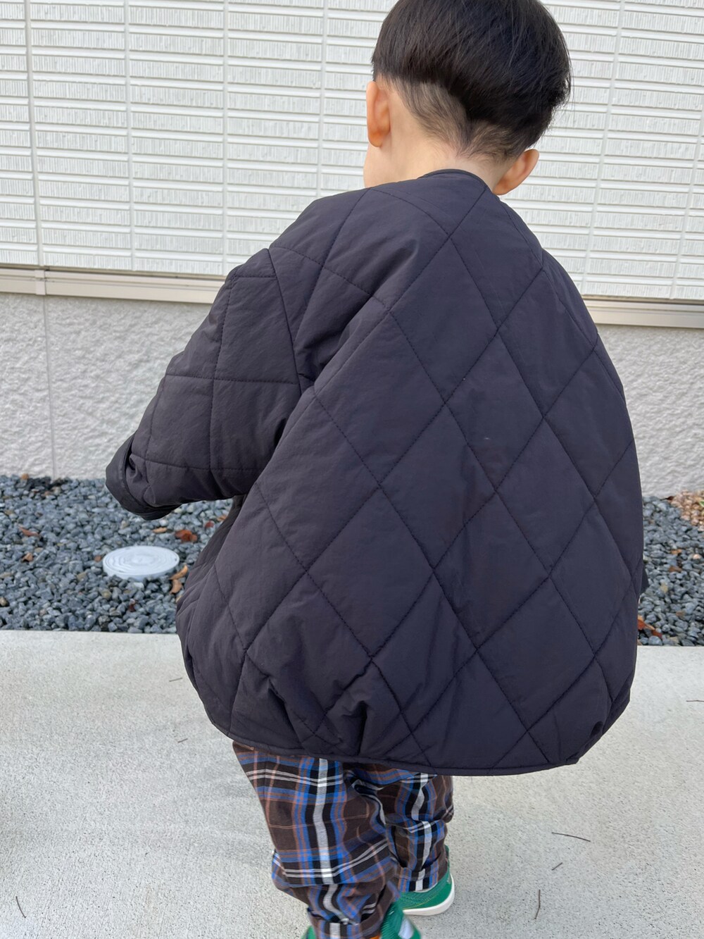 ブラック系のブルゾン、グリーン系のTシャツ/カットソー、ブラウン系のパンツを着用したキッズの秋コーディネートの4枚目の写真