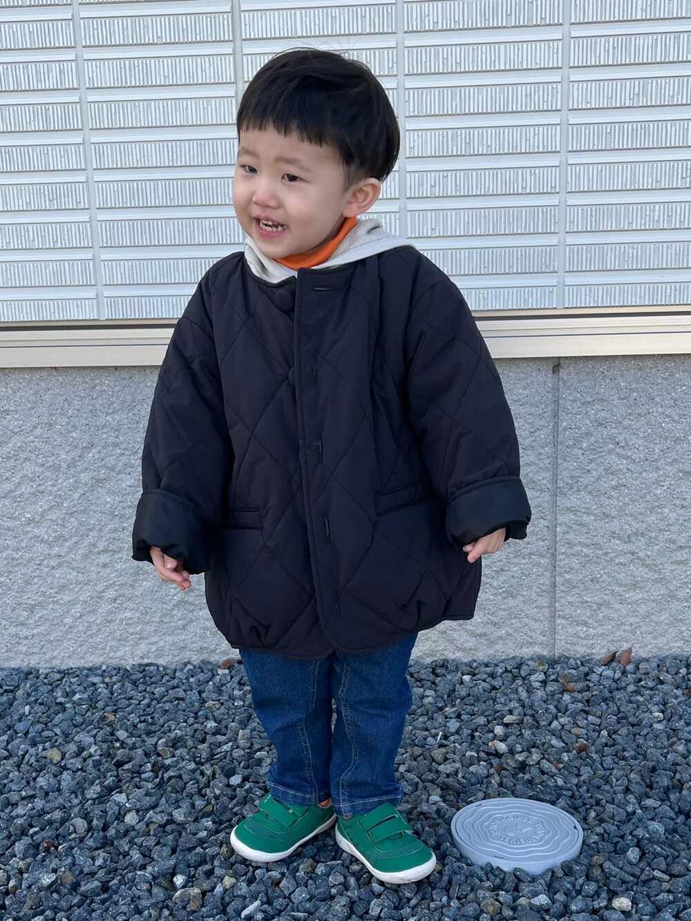 ブラック系のブルゾン、オレンジ系のTシャツ/カットソー、ベージュ系のパーカーを着用したキッズの冬コーディネートの3枚目の写真