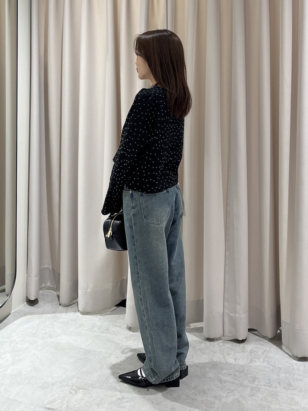 ブラック系のシャツ/ブラウス、ブルー系のデニムパンツ、ブラック系のボストンバッグを着用したレディースの春コーディネートの2枚目の写真