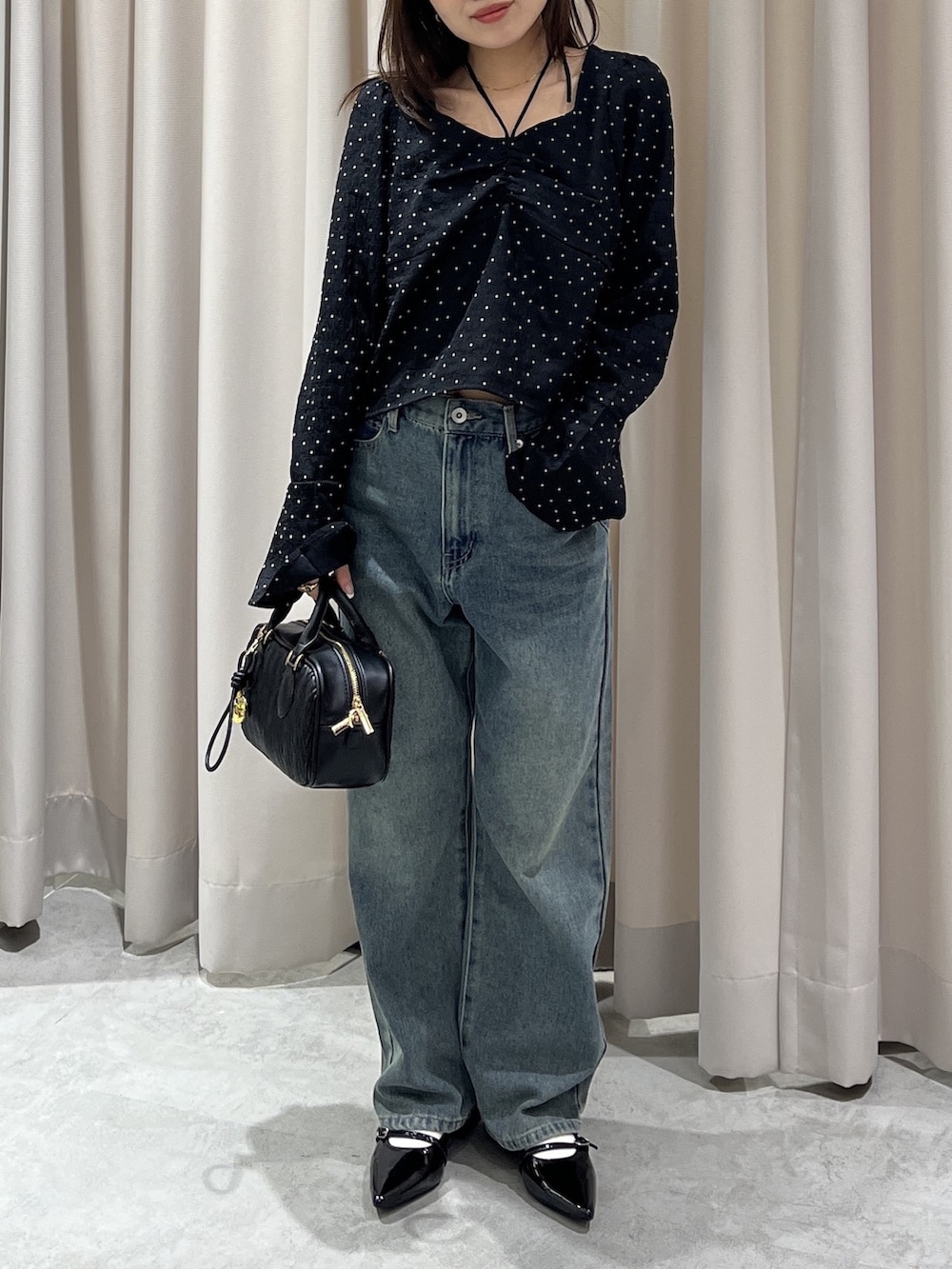 ブラック系のシャツ/ブラウス、ブルー系のデニムパンツ、ブラック系のボストンバッグを着用したレディースの春コーディネートの3枚目の写真