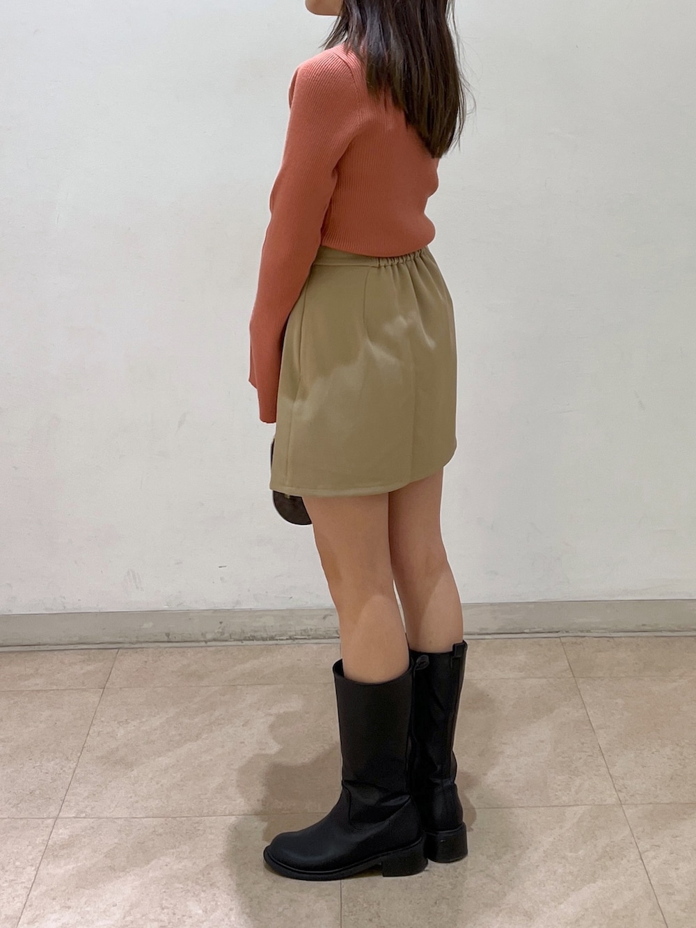 オレンジ系のニット/セーター、ベージュ系のその他パンツを着用したレディースの秋コーディネートの3枚目の写真