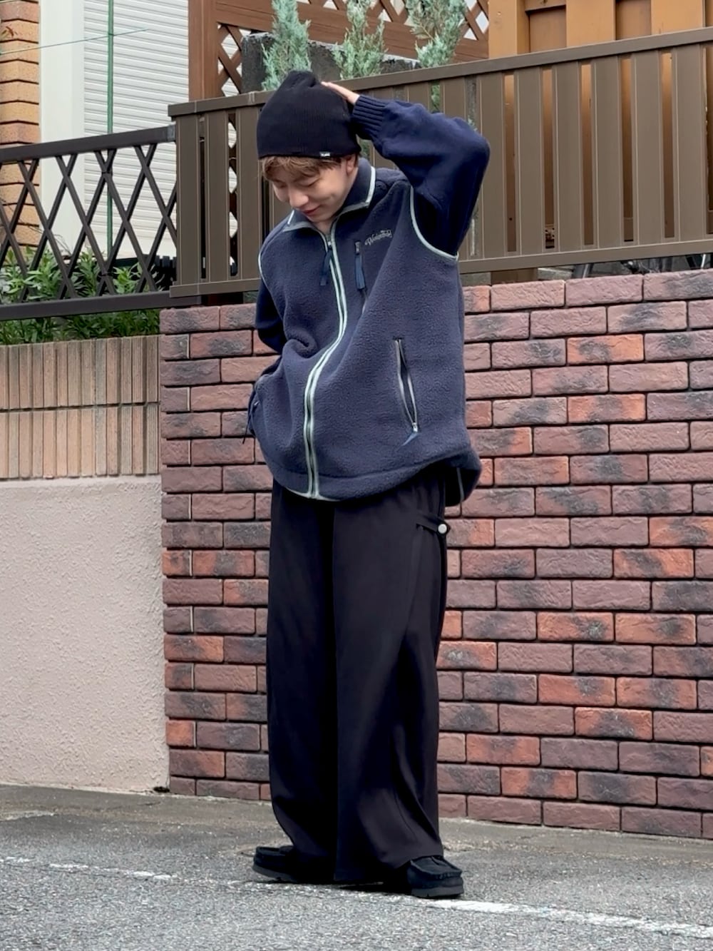 ブラック系のスニーカー、ブラック系のスウェットパンツ、ブルー系のベストを着用したメンズの秋コーディネートの2枚目の写真