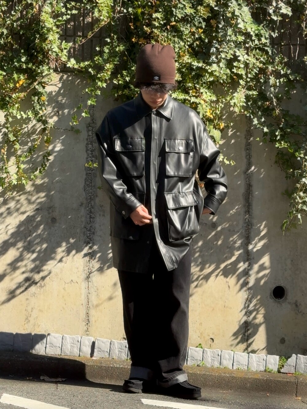 ブラック系のライダースジャケット、ブラック系のデニムパンツ、ブラック系のスニーカーを着用したメンズの秋コーディネートの2枚目の写真