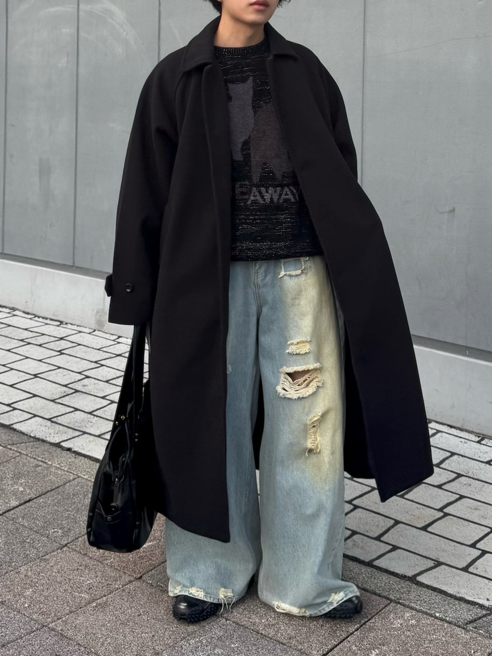 ブラック系のニット/セーター、ブルー系のデニムパンツ、ブラック系のステンカラーコートを着用したメンズの冬コーディネートの2枚目の写真