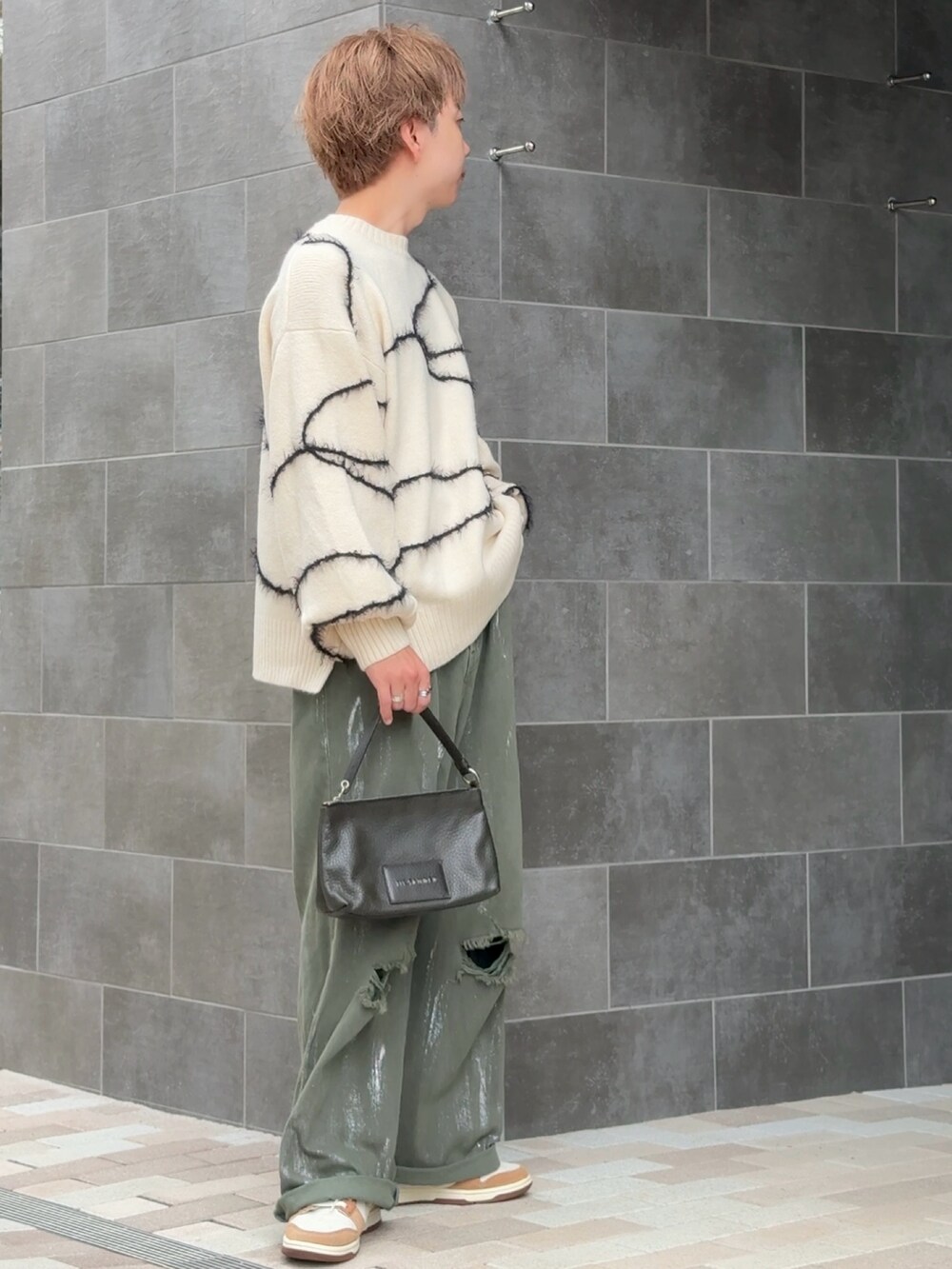 グリーン系のデニムパンツ、ホワイト系のニット/セーター、ベージュ系のスニーカーを着用したメンズの秋コーディネートの2枚目の写真