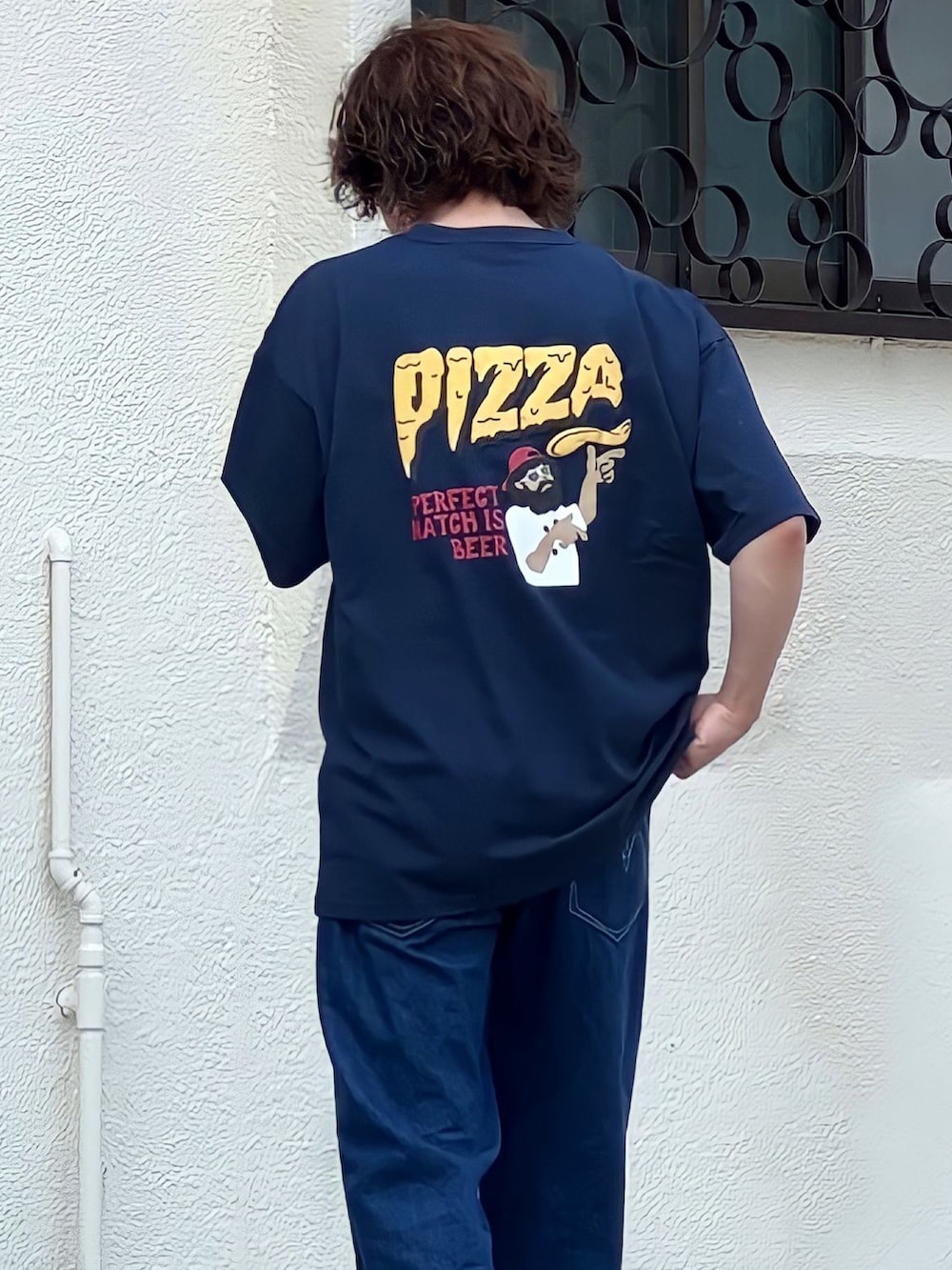 ブルー系のデニムパンツ、ブラック系のTシャツ/カットソー、ベージュ系のブーツを着用したメンズの夏コーディネートの2枚目の写真