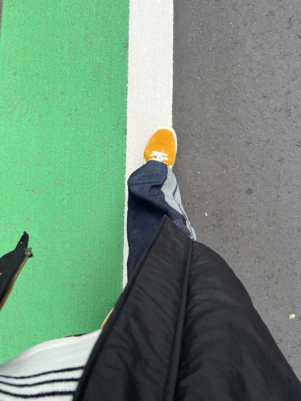 イエロー系のスニーカー、ブラック系のジャケット/アウター、ブルー系のTシャツ/カットソーを着用したメンズの秋コーディネートの2枚目の写真