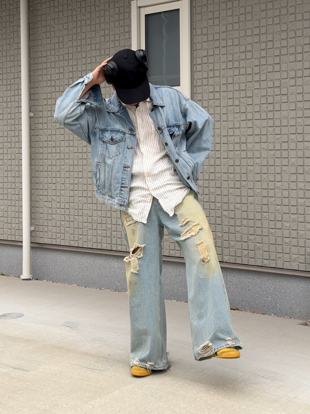 ブルー系のデニムパンツ、イエロー系のスニーカー、ホワイト系のシャツ/ブラウスを着用したメンズの秋コーディネートの2枚目の写真