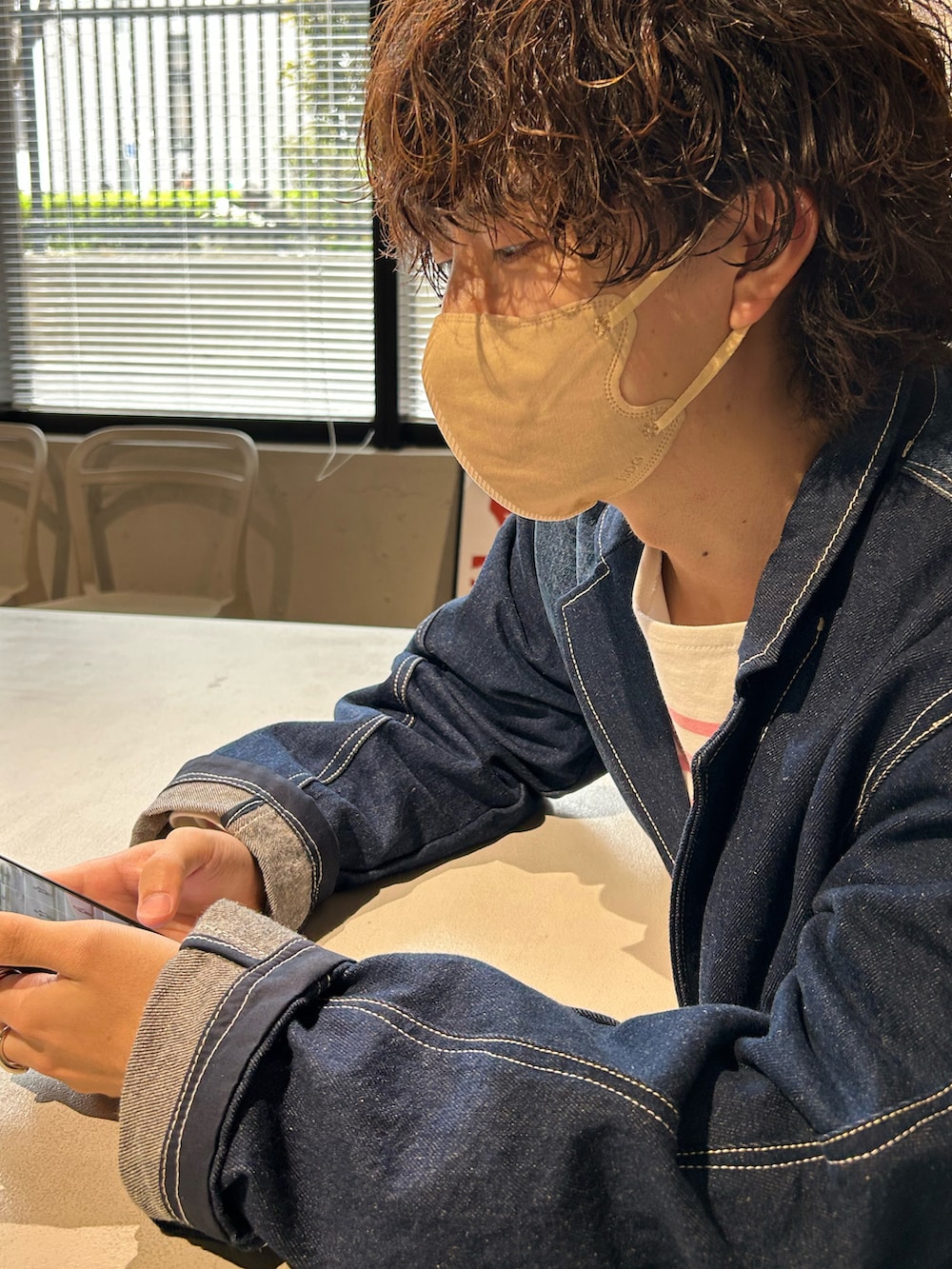 ブルー系のデニムジャケット、ブルー系のデニムパンツ、グリーン系のトートバッグを着用したメンズの春コーディネートの3枚目の写真