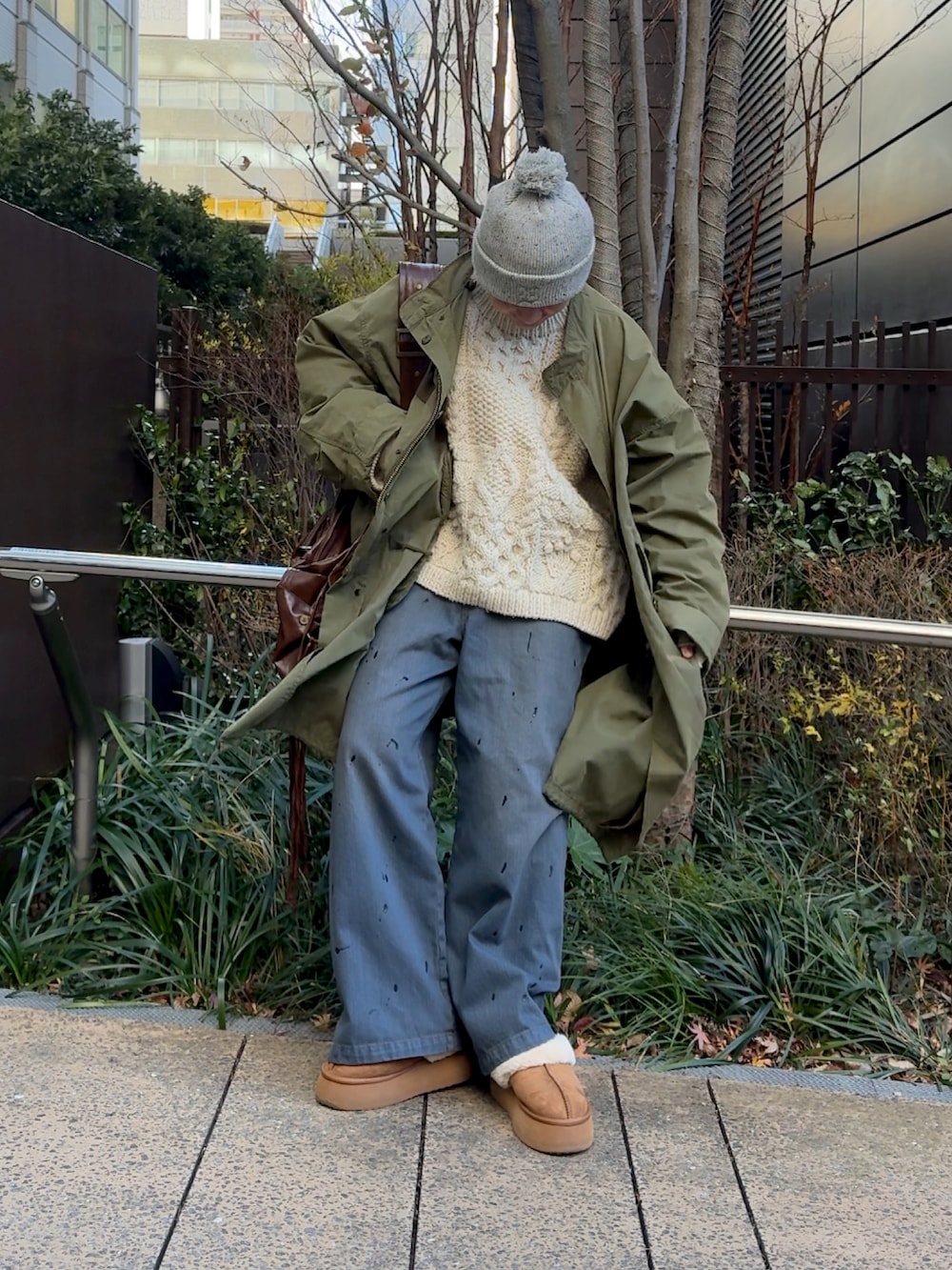 ブラック系のデニムパンツ、ホワイト系のニット/セーター、ブラウン系のショルダーバッグを着用したメンズの冬コーディネートの2枚目の写真