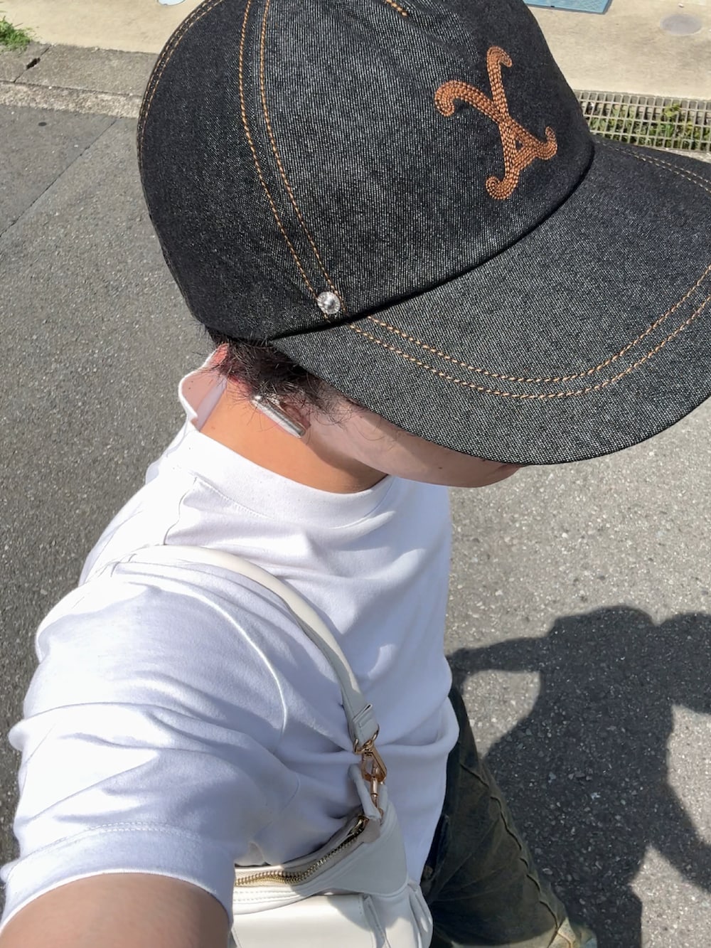 ブルー系のデニムパンツ、ホワイト系のTシャツ/カットソー、ブラウン系のスニーカーを着用したメンズの夏コーディネートの3枚目の写真