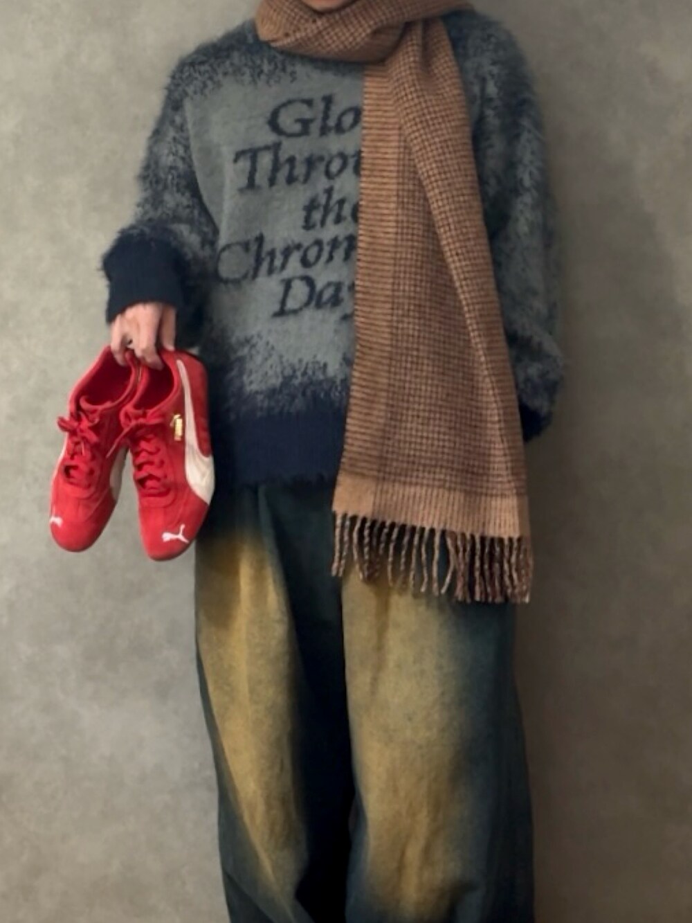 ブラック系のニット/セーター、ブルー系のデニムパンツ、レッド系のスニーカーを着用したメンズの秋コーディネートの2枚目の写真