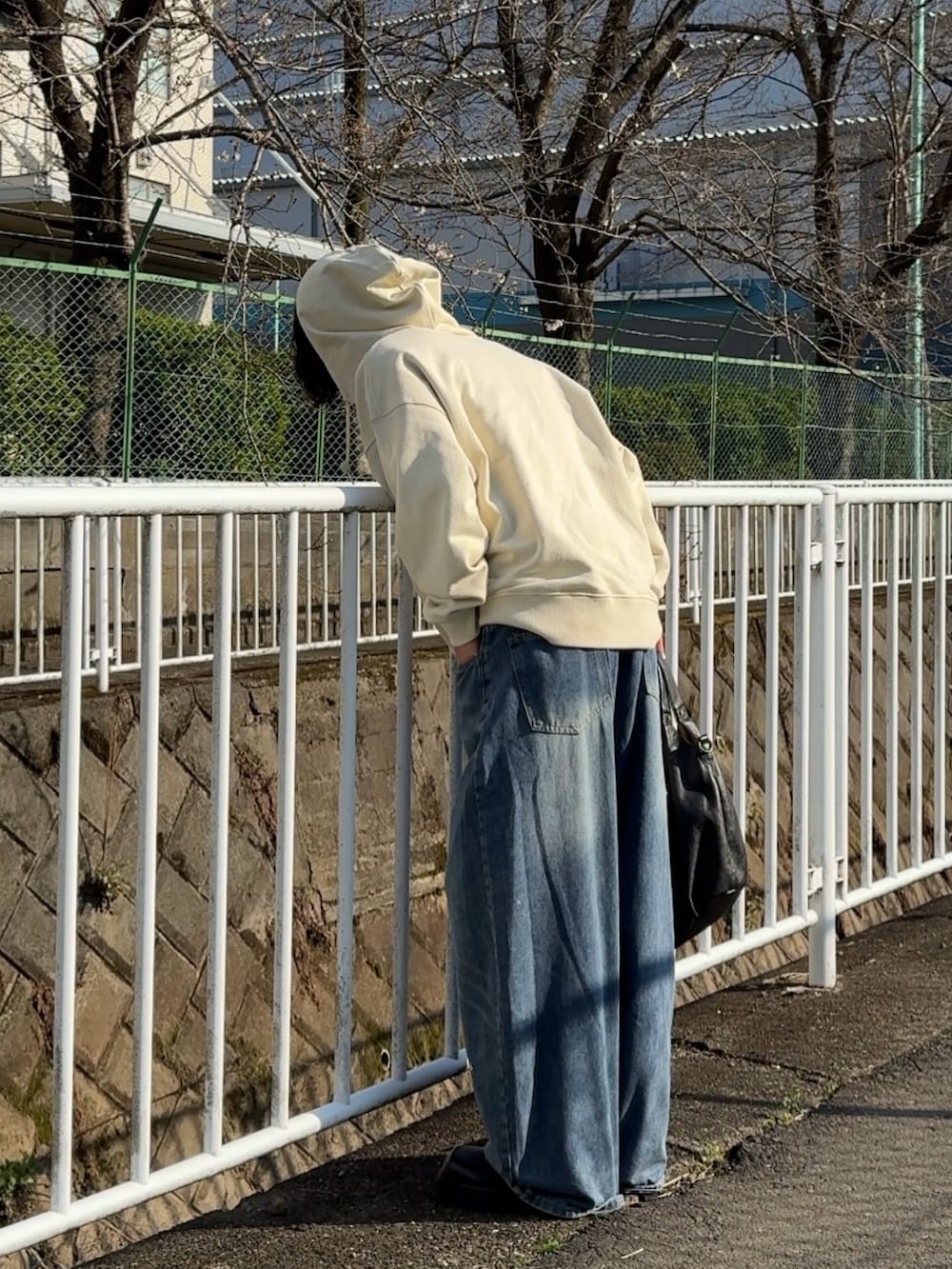 ブラック系のショルダーバッグ、ホワイト系のパーカー、グリーン系のTシャツ/カットソーを着用したメンズの春コーディネートの2枚目の写真