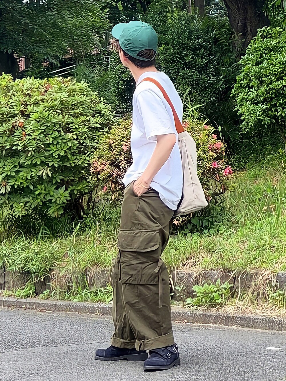 ホワイト系のTシャツ/カットソー、ベージュ系のショルダーバッグ、グリーン系のカーゴパンツを着用したメンズの夏コーディネートの2枚目の写真