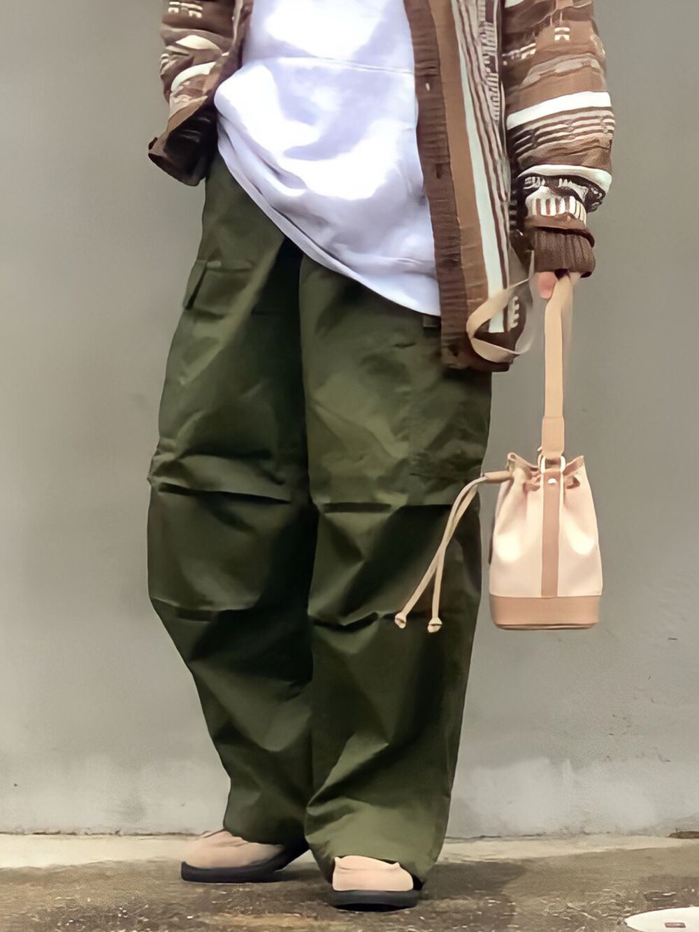 ベージュ系のハンドバッグ、ブラウン系のカーディガン/ボレロ、グレー系のパーカーを着用したメンズの冬コーディネートの2枚目の写真