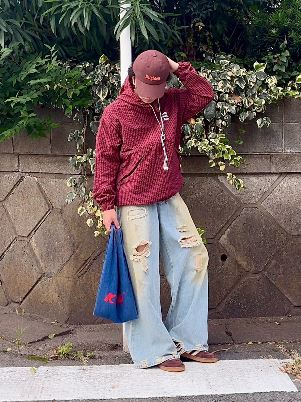 ブルー系のデニムパンツ、レッド系のブルゾン、ブルー系のショルダーバッグを着用したメンズの秋コーディネートの3枚目の写真