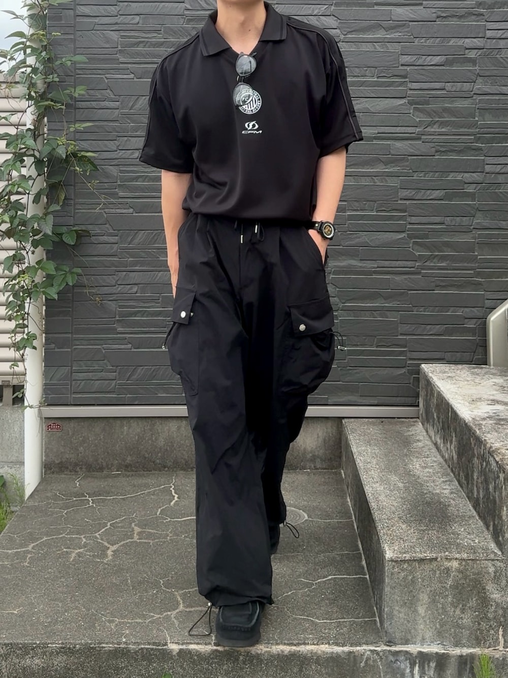 ブラック系のカーゴパンツ、ブラック系のスニーカー、ブラック系のTシャツ/カットソーを着用したメンズの夏コーディネートの2枚目の写真