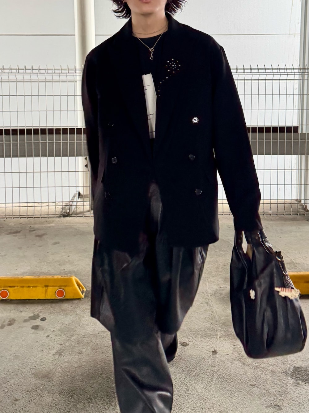 ブラック系のテーラードジャケット、ブラック系のショルダーバッグ、ブラック系のその他パンツを着用したメンズの春コーディネートの2枚目の写真