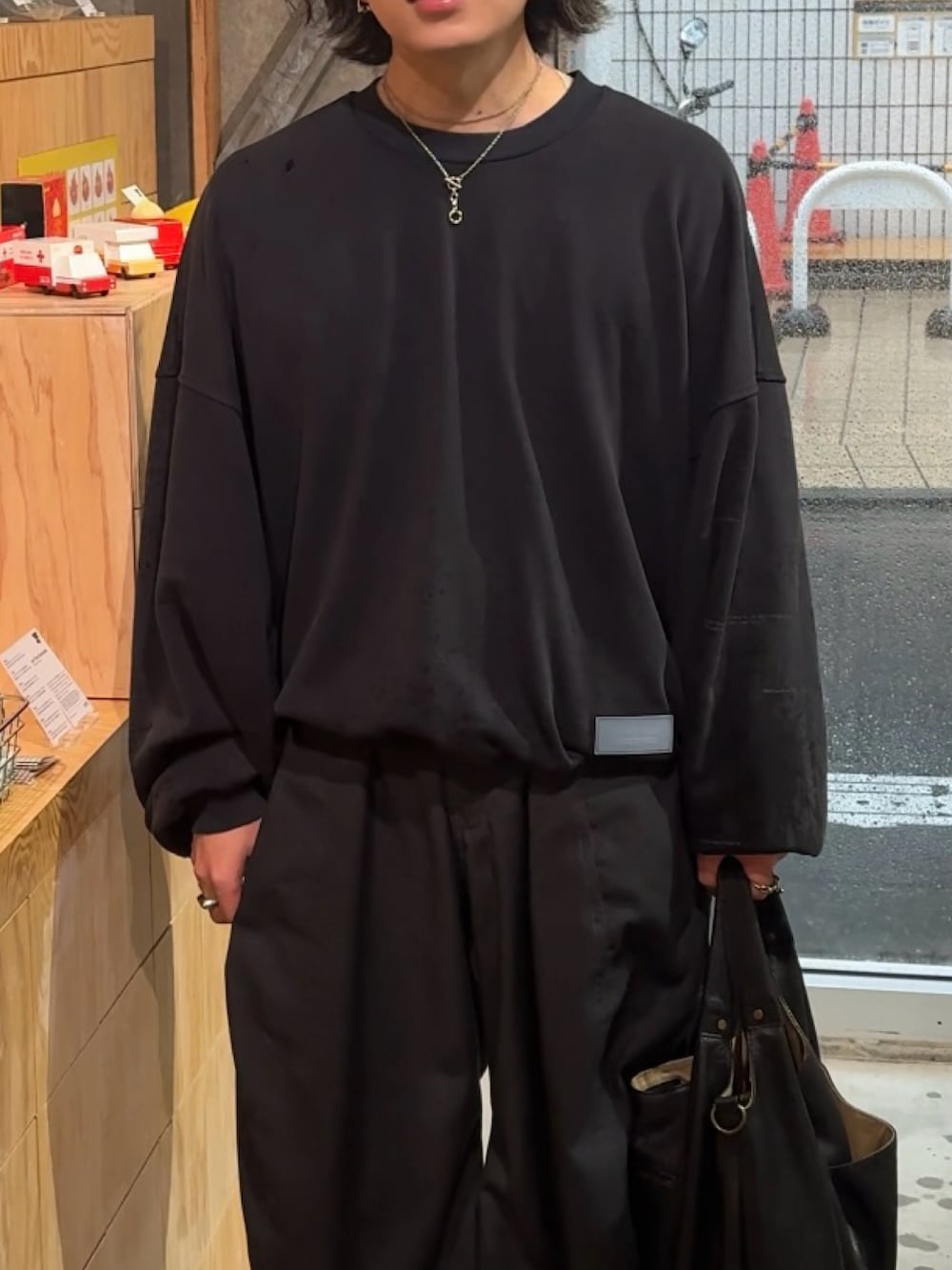 ブルー系のスウェット、グレー系のデニムパンツ、ブラック系のショルダーバッグを着用したメンズの春コーディネートの2枚目の写真