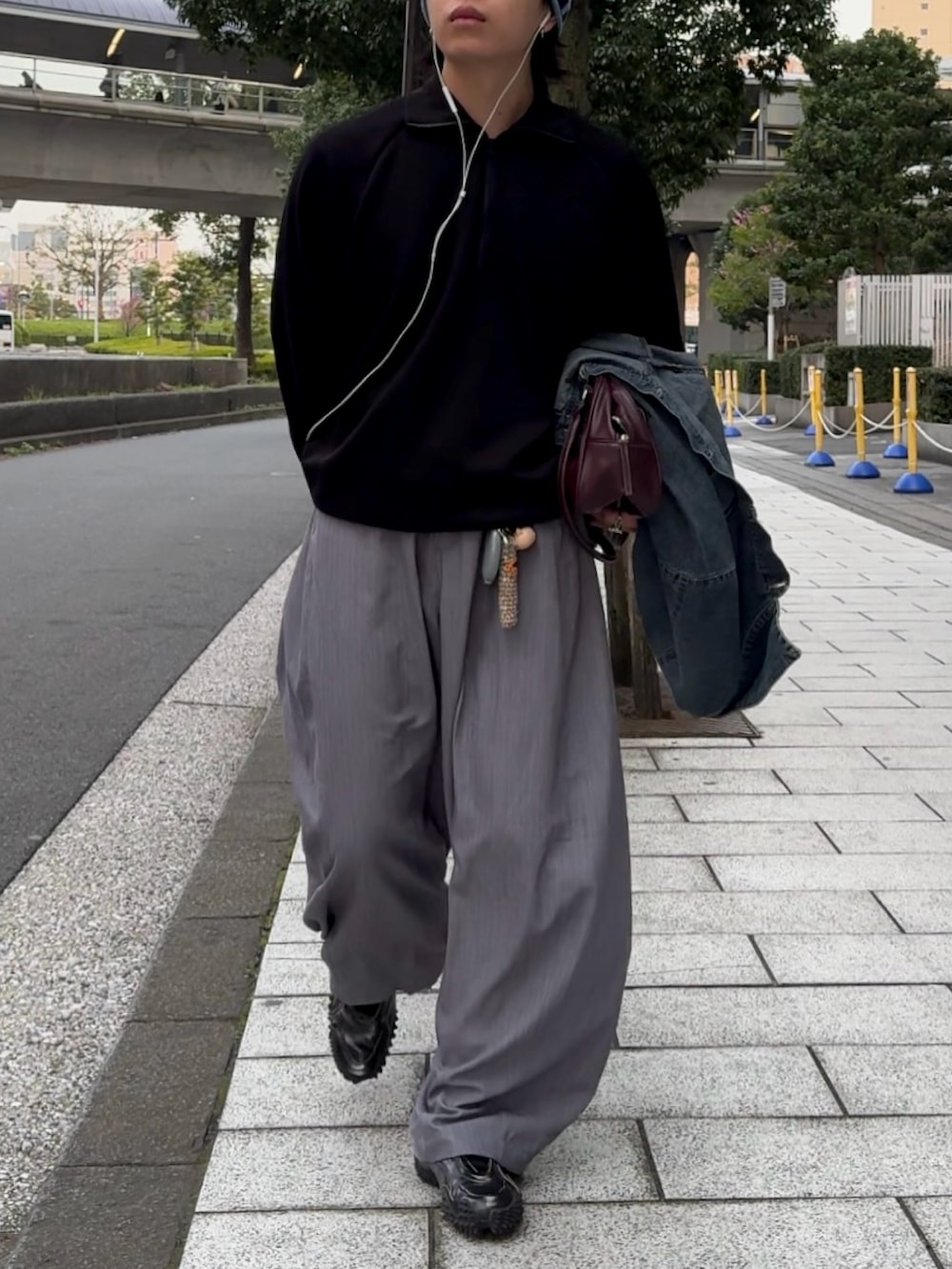 ブラック系のスウェット、ブラック系のスニーカー、グレー系のスラックスを着用したメンズの春コーディネートの2枚目の写真