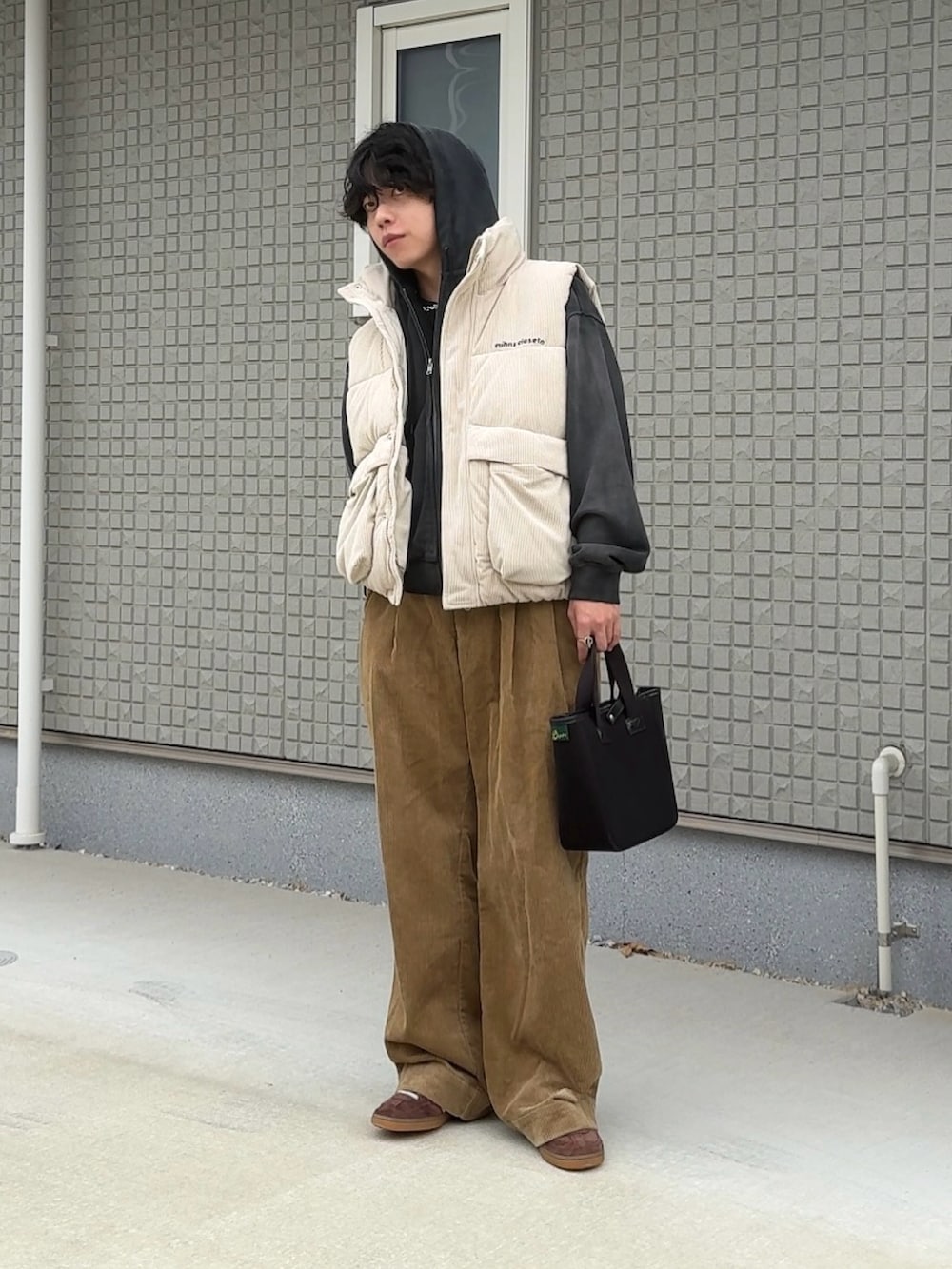 ブラック系のトートバッグ、ベージュ系のその他パンツ、ブラウン系のスニーカーを着用したメンズの秋コーディネートの2枚目の写真