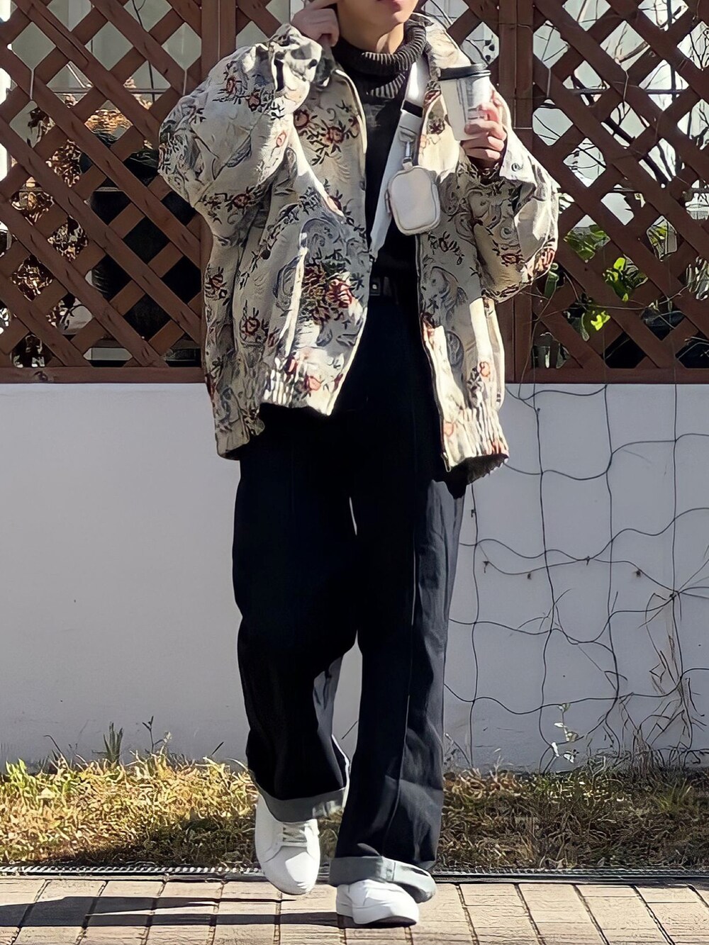 ベージュ系のブルゾン、ホワイト系のスニーカー、ホワイト系のショルダーバッグを着用したメンズの冬コーディネートの2枚目の写真