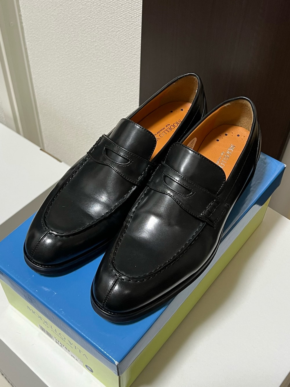 ブラック系のハンドバッグ、ブルー系のデニムパンツ、ブラック系のローファーを着用したメンズの秋コーディネートの5枚目の写真