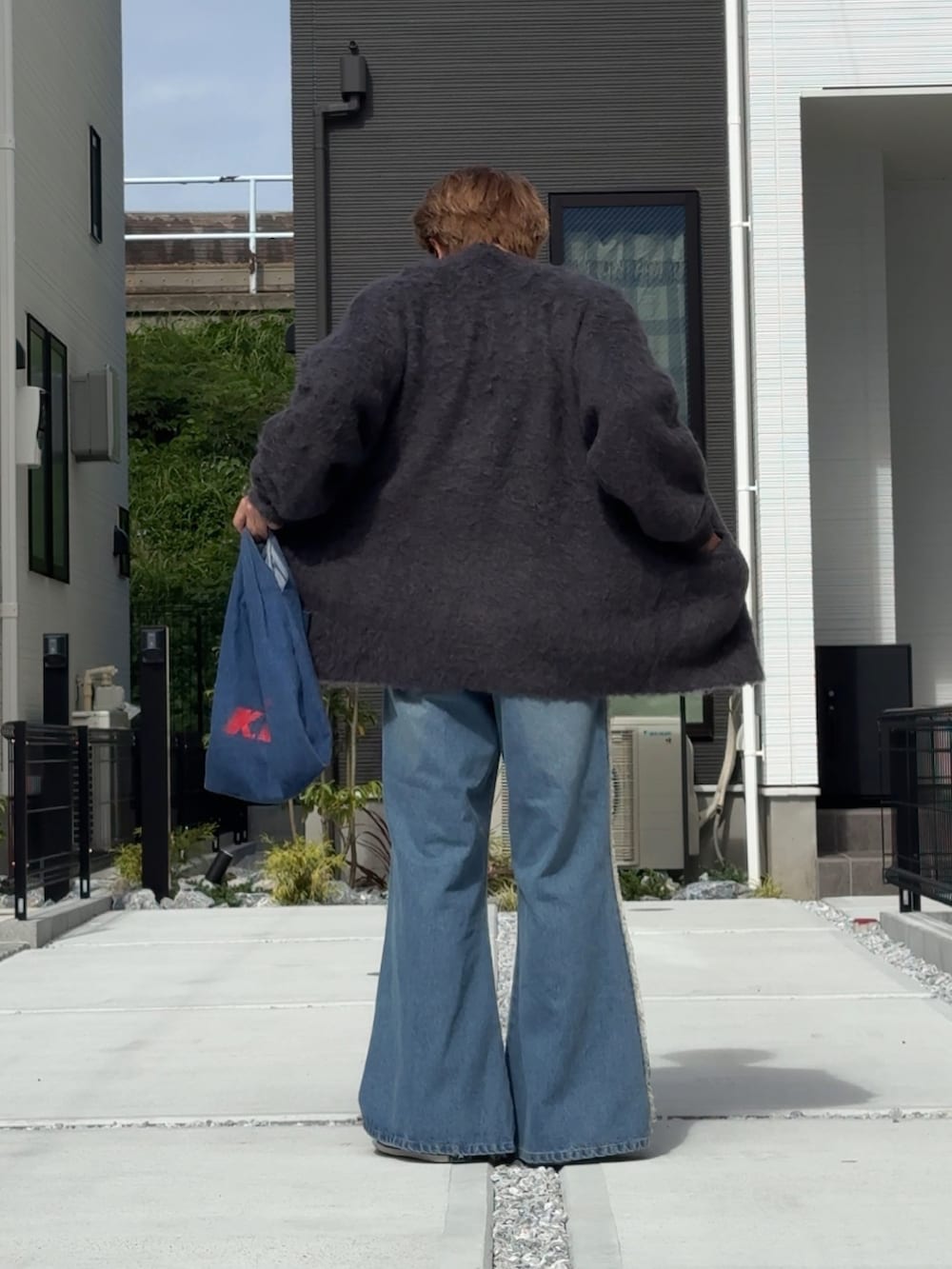 ブルー系のデニムパンツ、ブラック系のカーディガン/ボレロ、グレー系のTシャツ/カットソーを着用したメンズの秋コーディネートの3枚目の写真