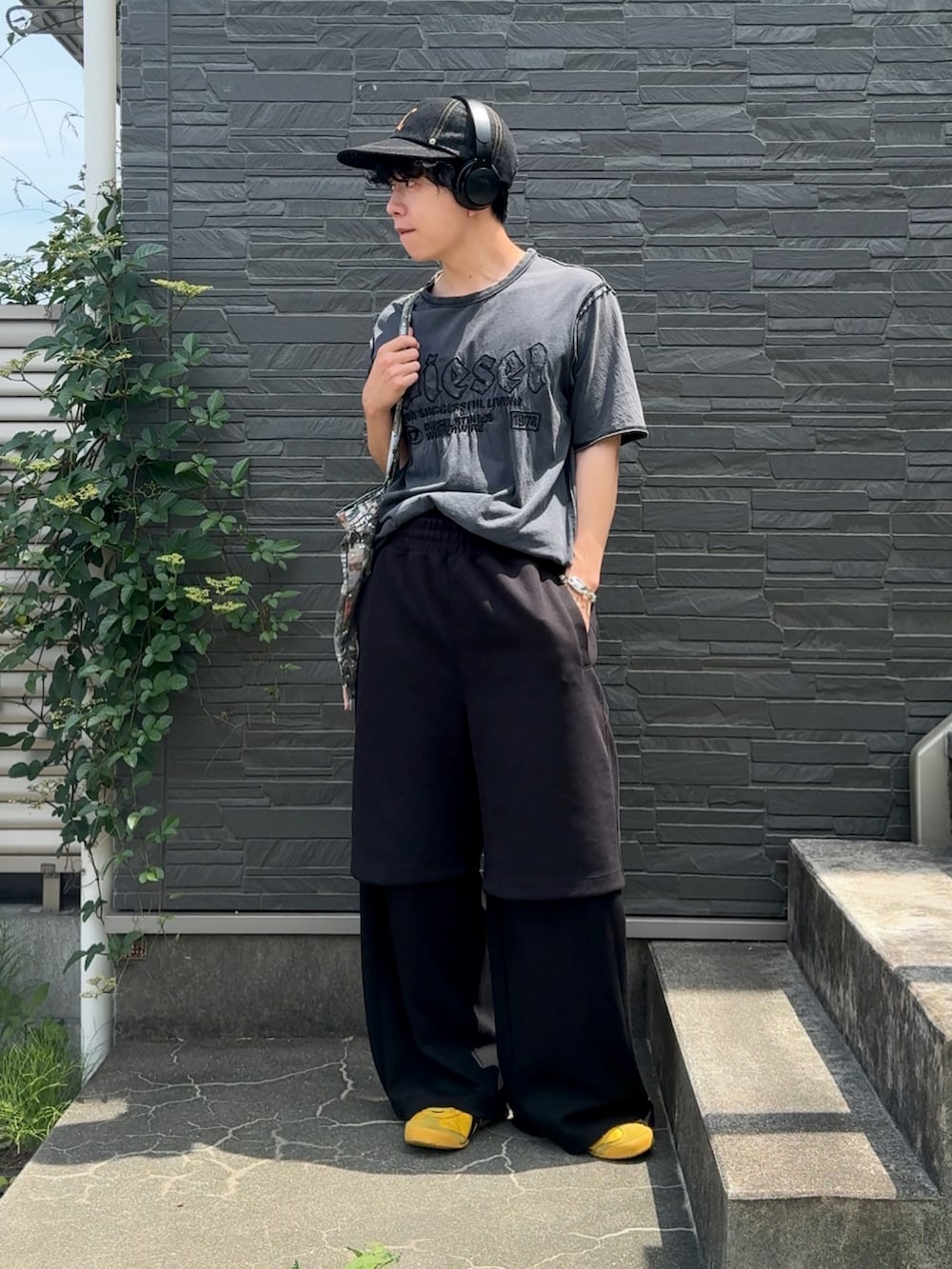 グレー系のTシャツ/カットソー、ブラック系のパンツ、イエロー系のスニーカーを着用したメンズの夏コーディネートの2枚目の写真