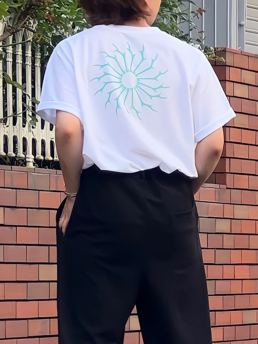 グリーン系のサンダル、ホワイト系のTシャツ/カットソー、ブラック系のスラックスを着用したメンズの夏コーディネートの2枚目の写真