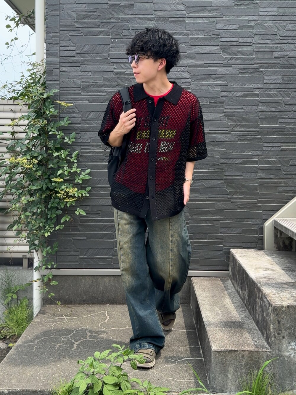 ブルー系のデニムパンツ、グリーン系のサンダル、レッド系のTシャツ/カットソーを着用したメンズの夏コーディネートの2枚目の写真