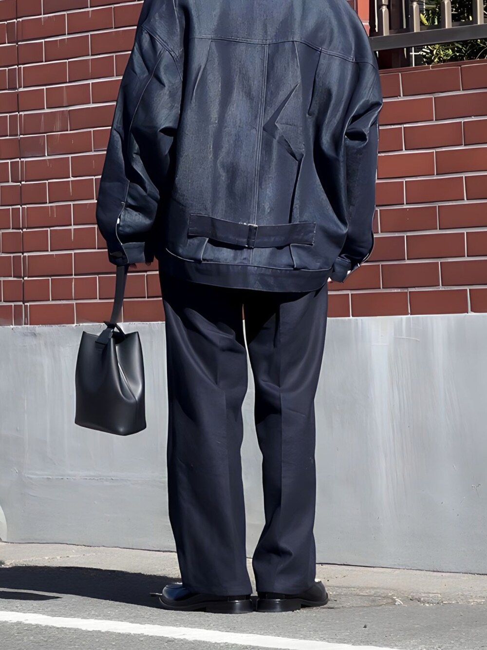 ブルー系のその他パンツ、ブラック系のハンドバッグ、ブラック系のローファーを着用したメンズの冬コーディネートの3枚目の写真